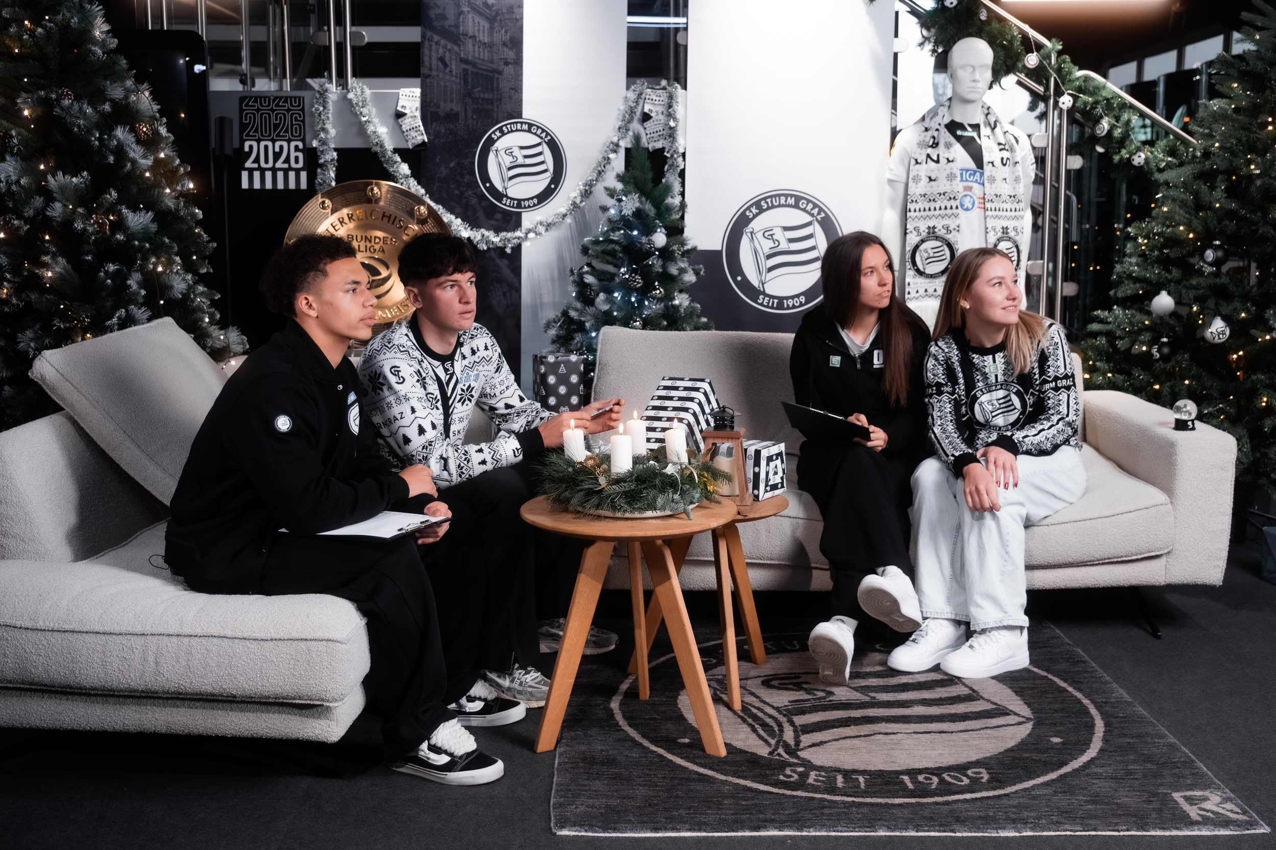 Vier Personen sitzen auf einer Couch