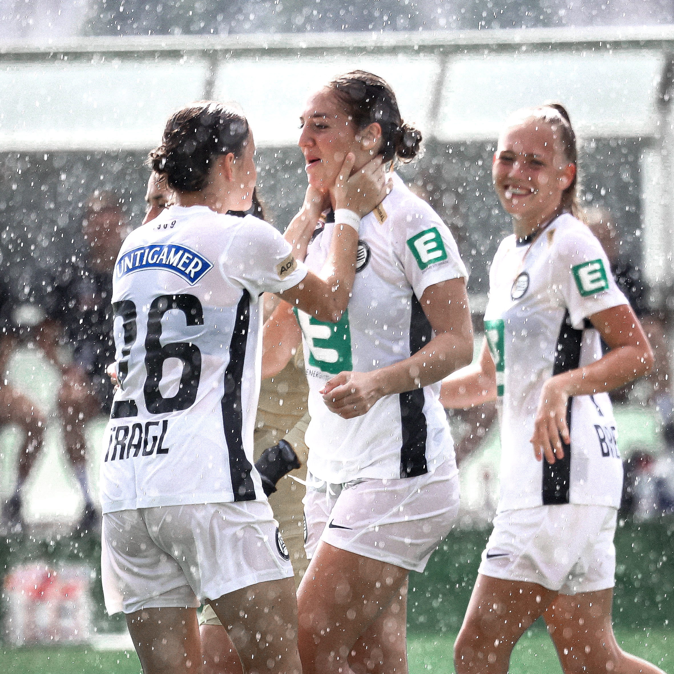 Man sieht jubelnde Spielerinnen im Regen.