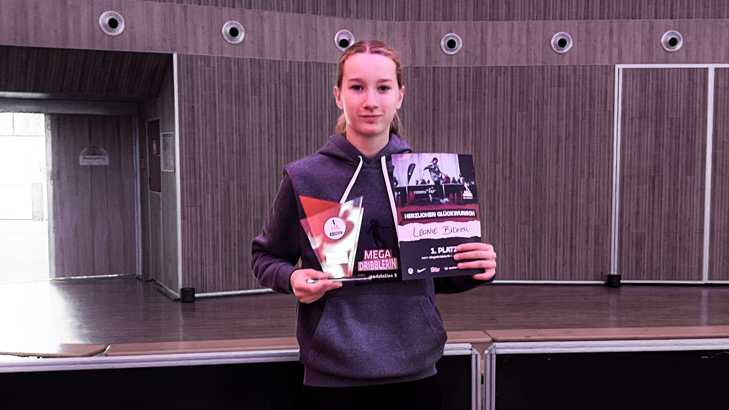 Eine Spielerin hält eine Urkunde hoch