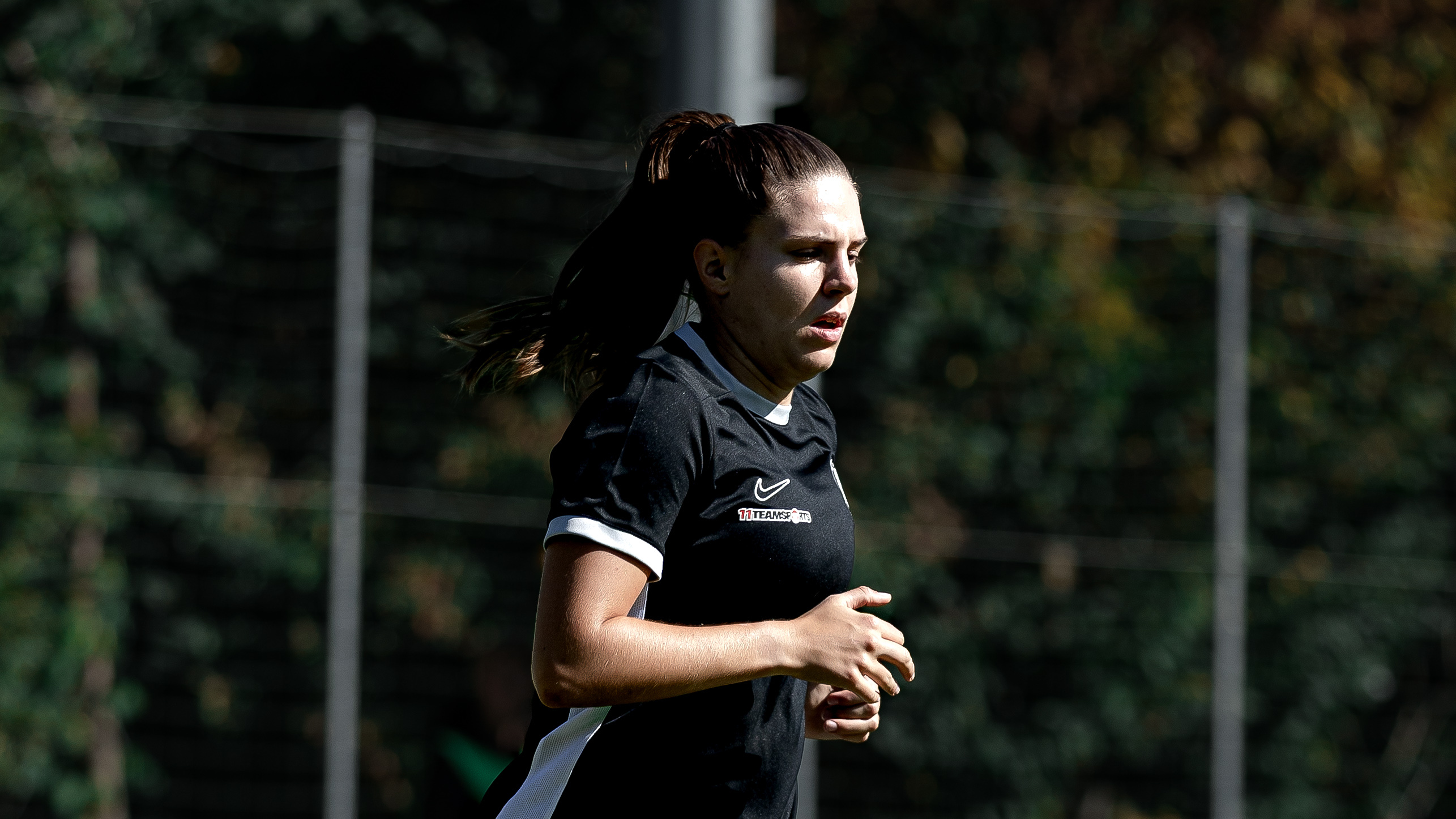 Eine Frau in schwarzem Shirt sieht man von der Seite.