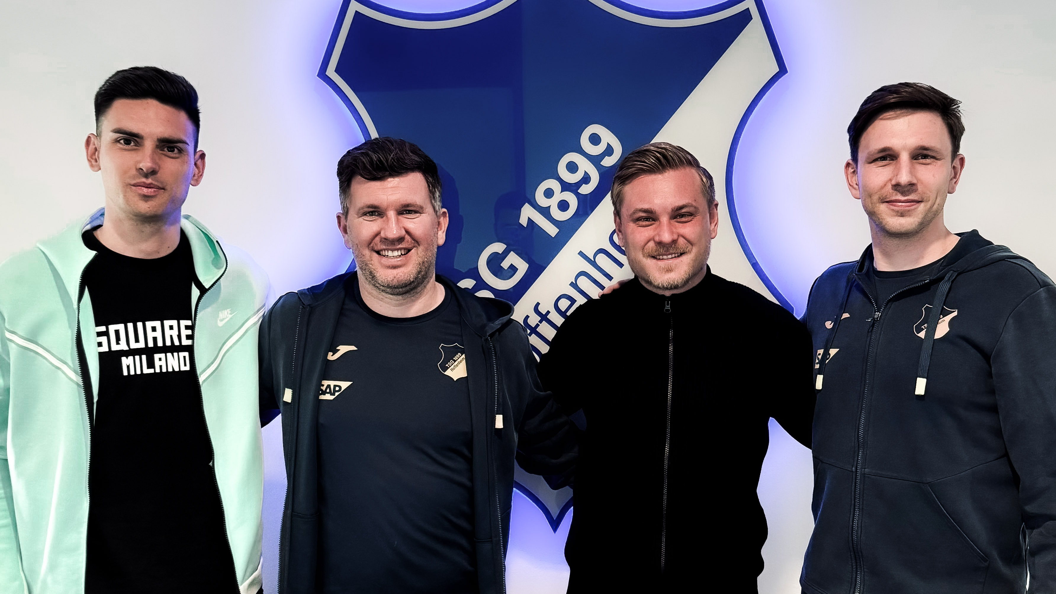 Vier Männer stehen nebeneinander und lachen