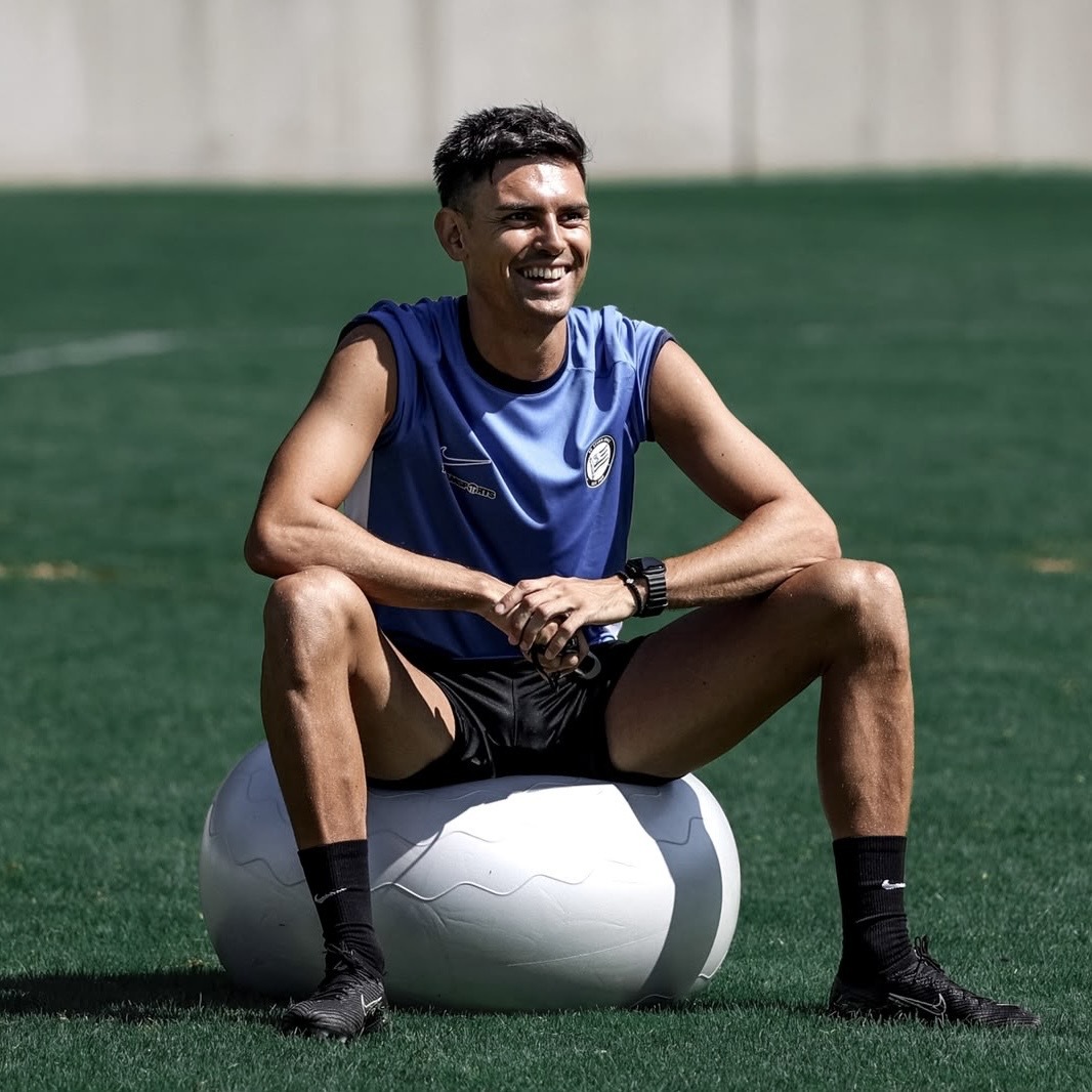 Ein Mann lächelt und sitzt auf einem Ball.