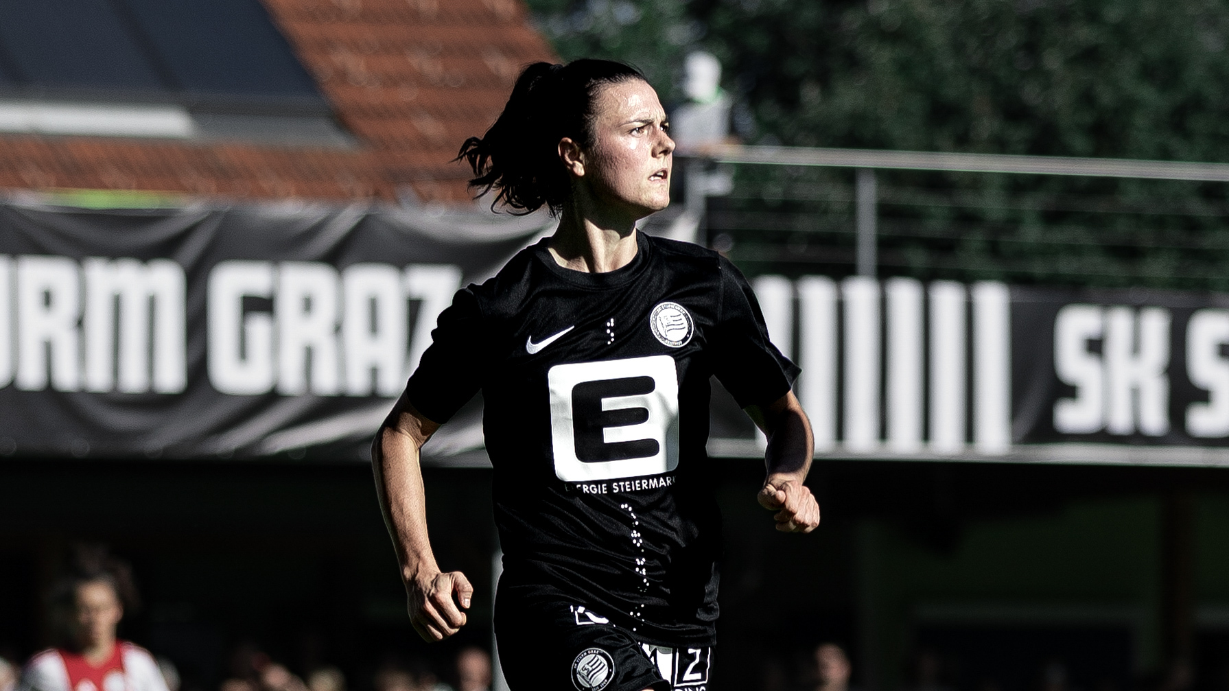 Eine Frau in schwarzem Trikot läuft. Man sieht sie von der Seite.