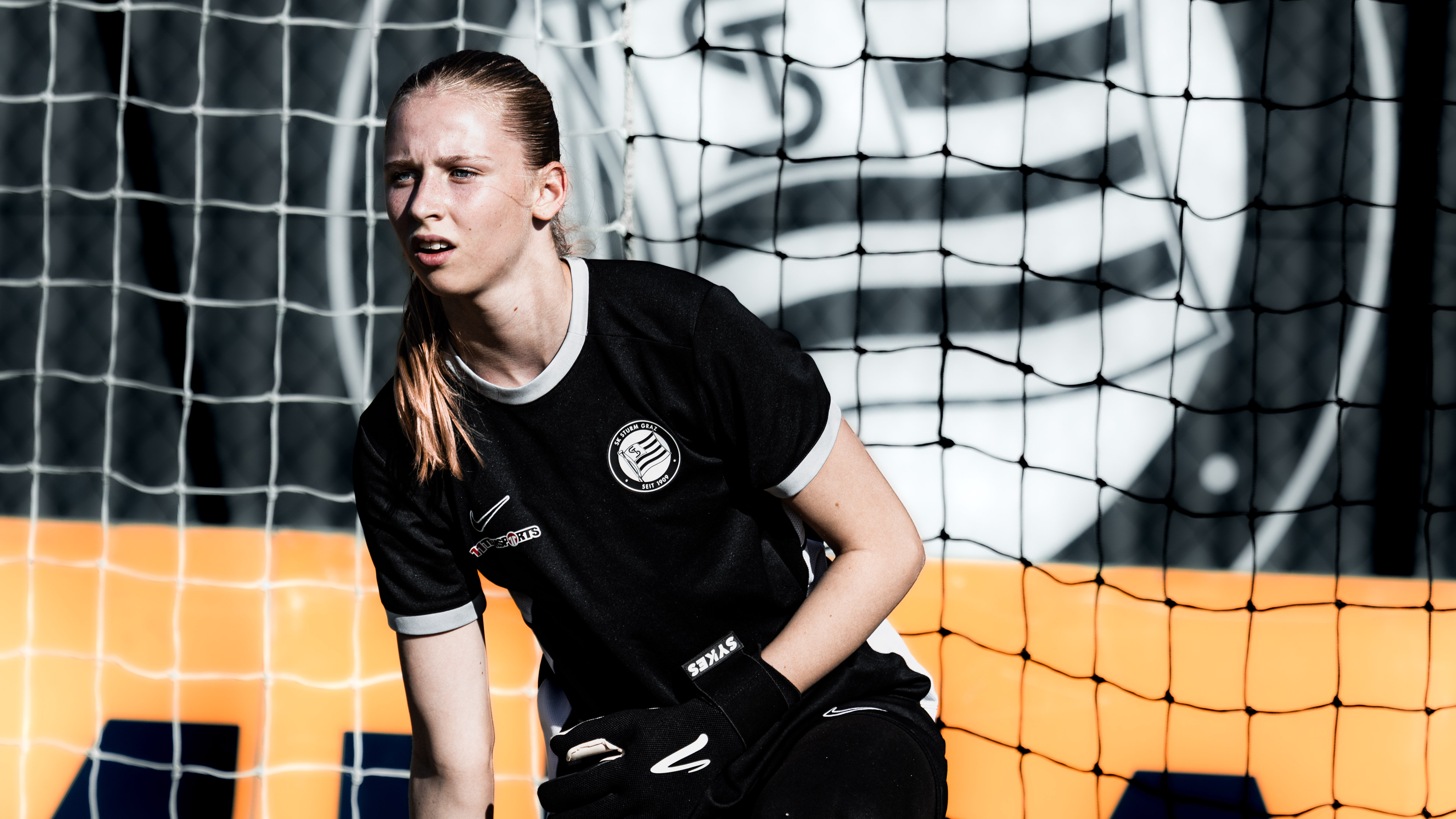 Eine Spielerin in einem schwarzen Trikot schaut in eine Richtung.