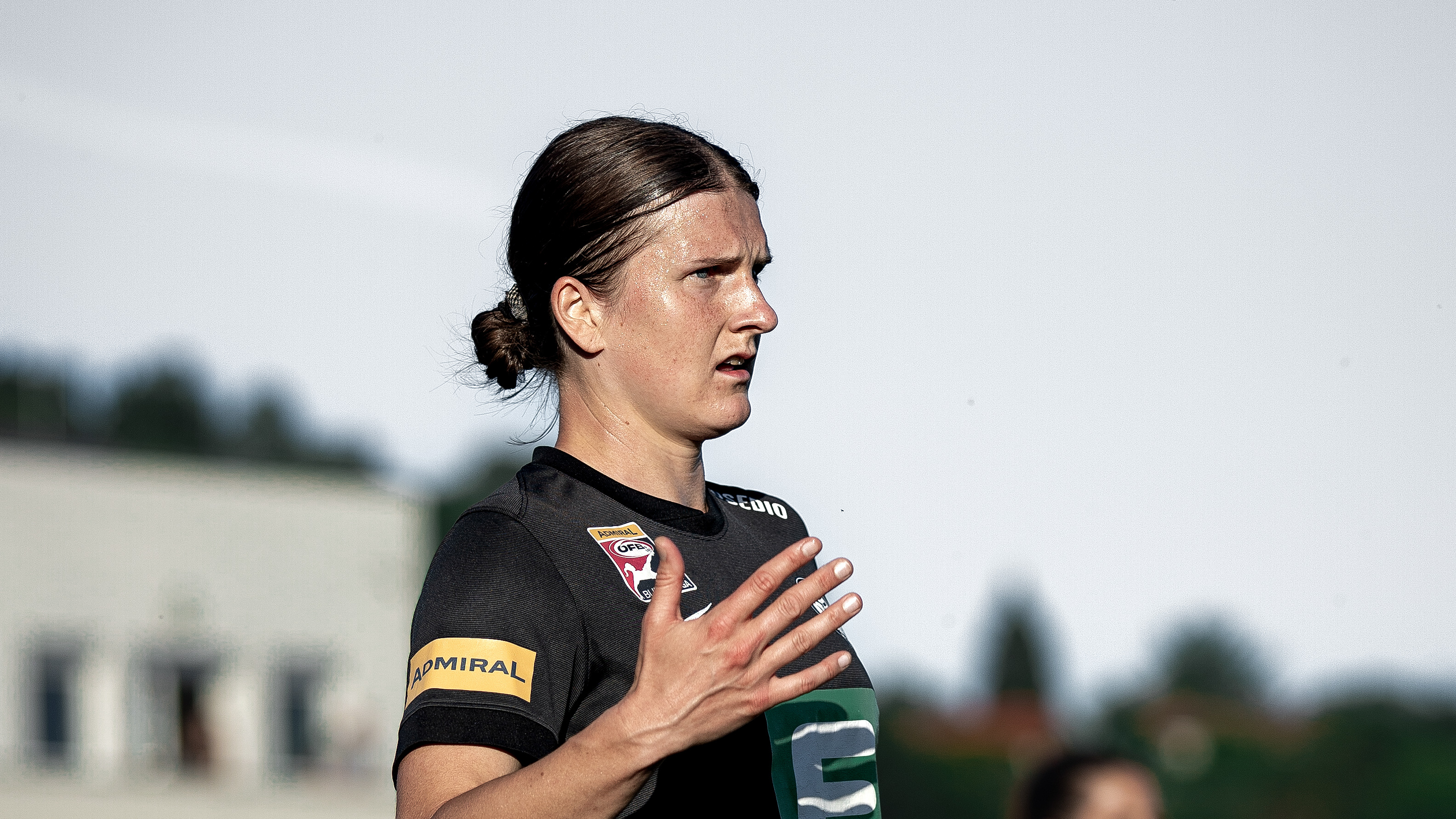 Eine Frau in schwarzem Trikot sieht man von der Seite.