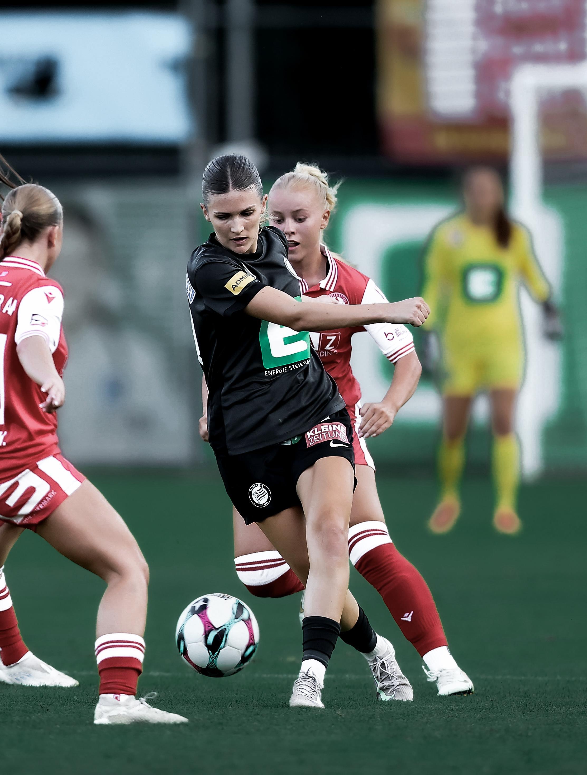 Eine Frau hate den Ball und zwei andere Frauen versuchen an den Ball zu kommen