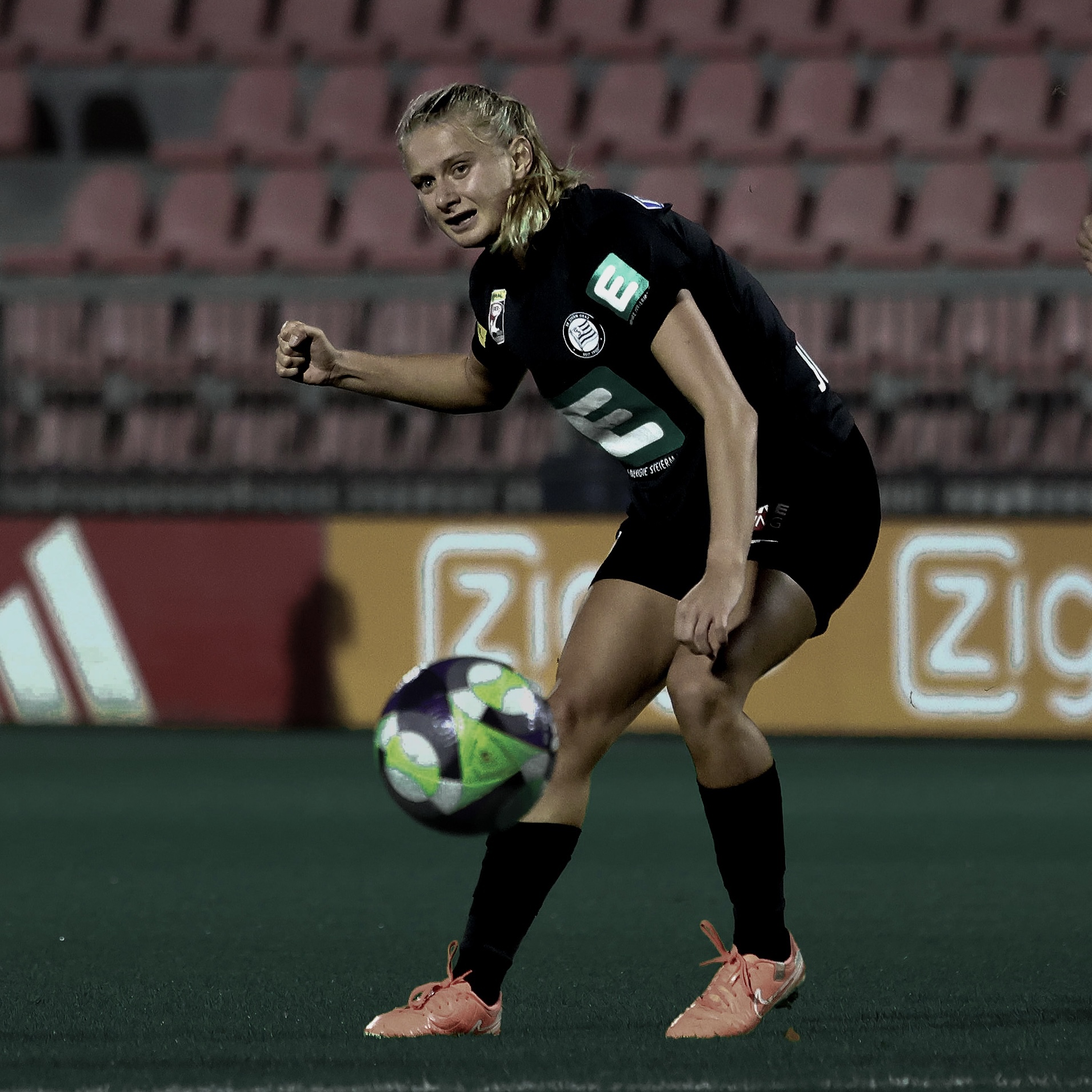 Eine Frau in schwarzem Trikot sieht den Ball an.