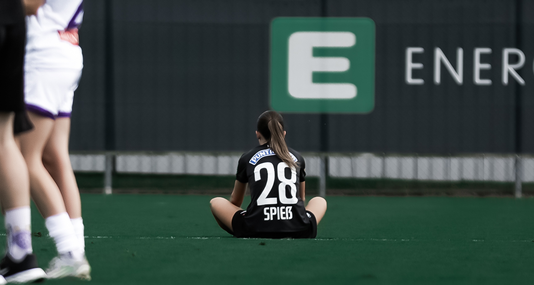 Eine Spielerin sitzt am Rasen