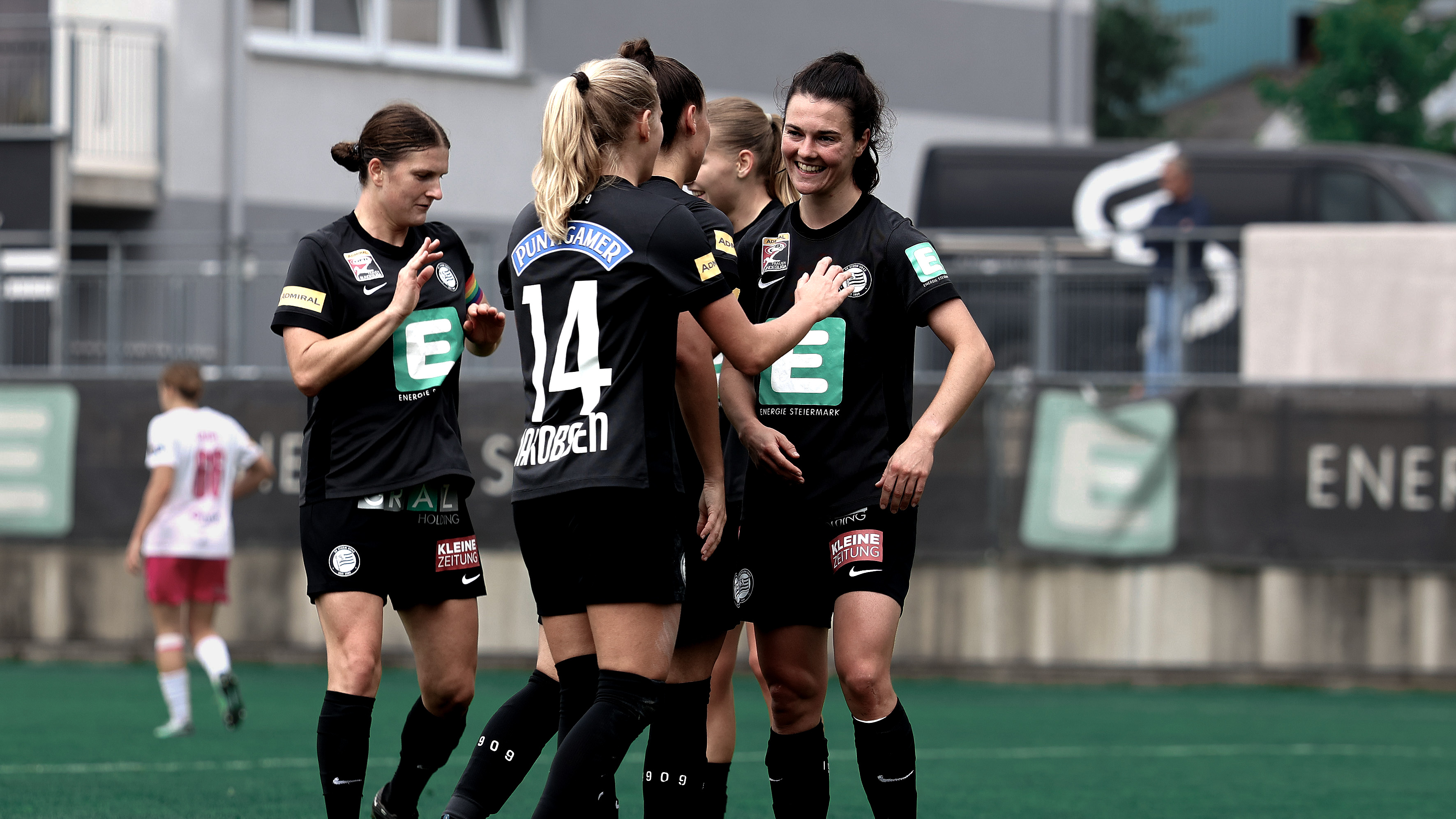 Einige Frauen in schwarzem Trikot jubeln gemeinsam.