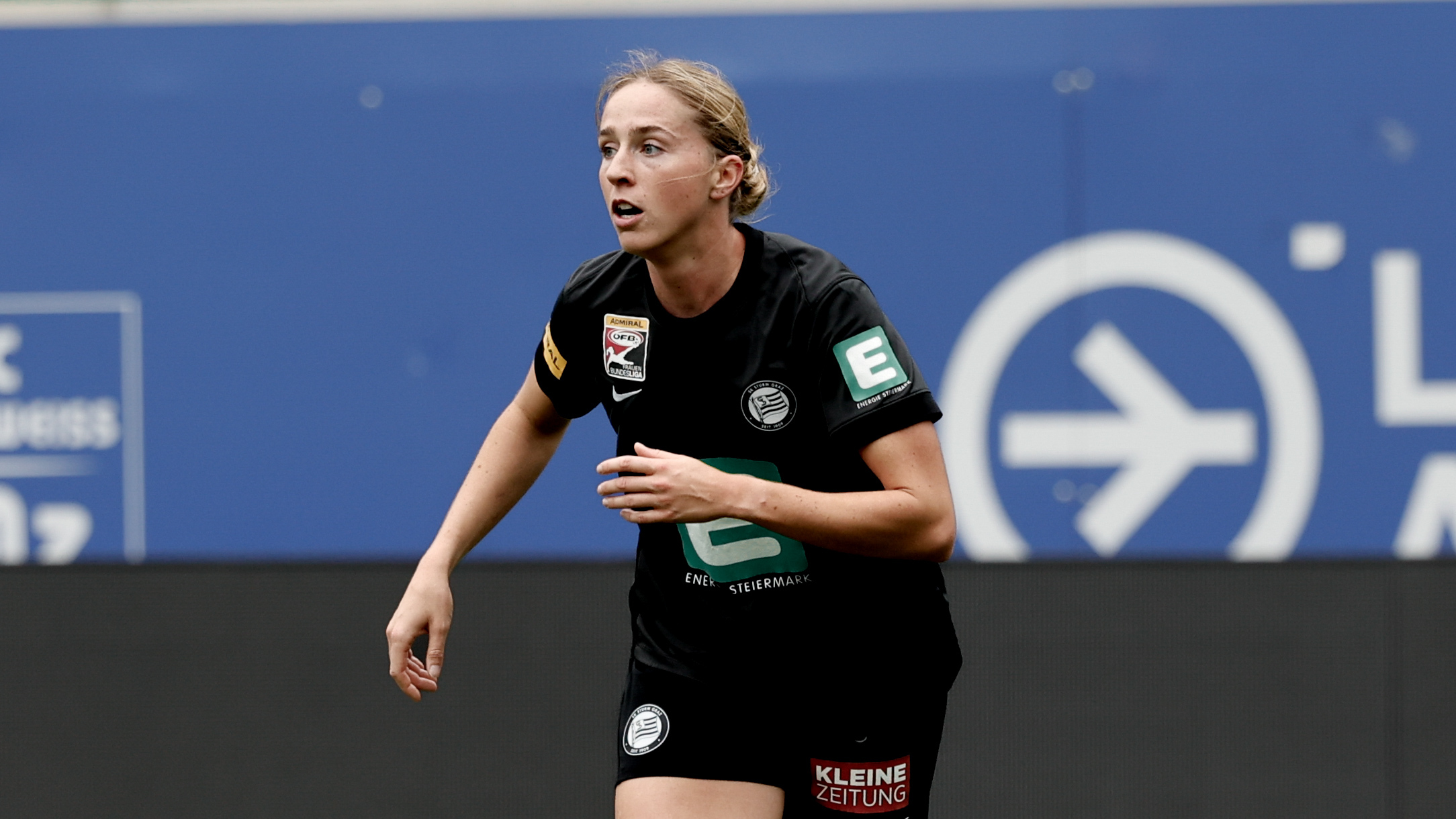 Eine Frau in schwarzem Trikot sieht in die Ferne.
