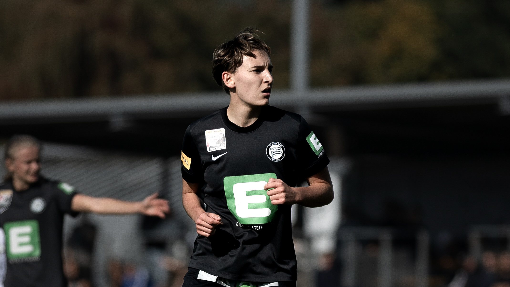 Eine Frau in einem schwarzem Trikot schaut in die ferne.