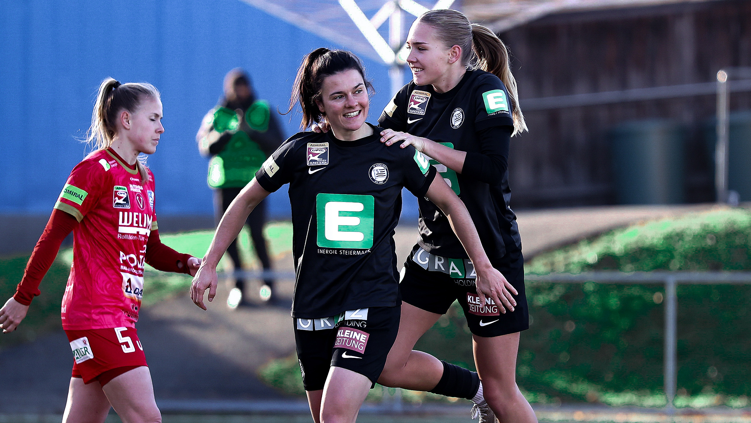 Zwei Frauen in schwarzen Trikots jubeln gemeinsam.