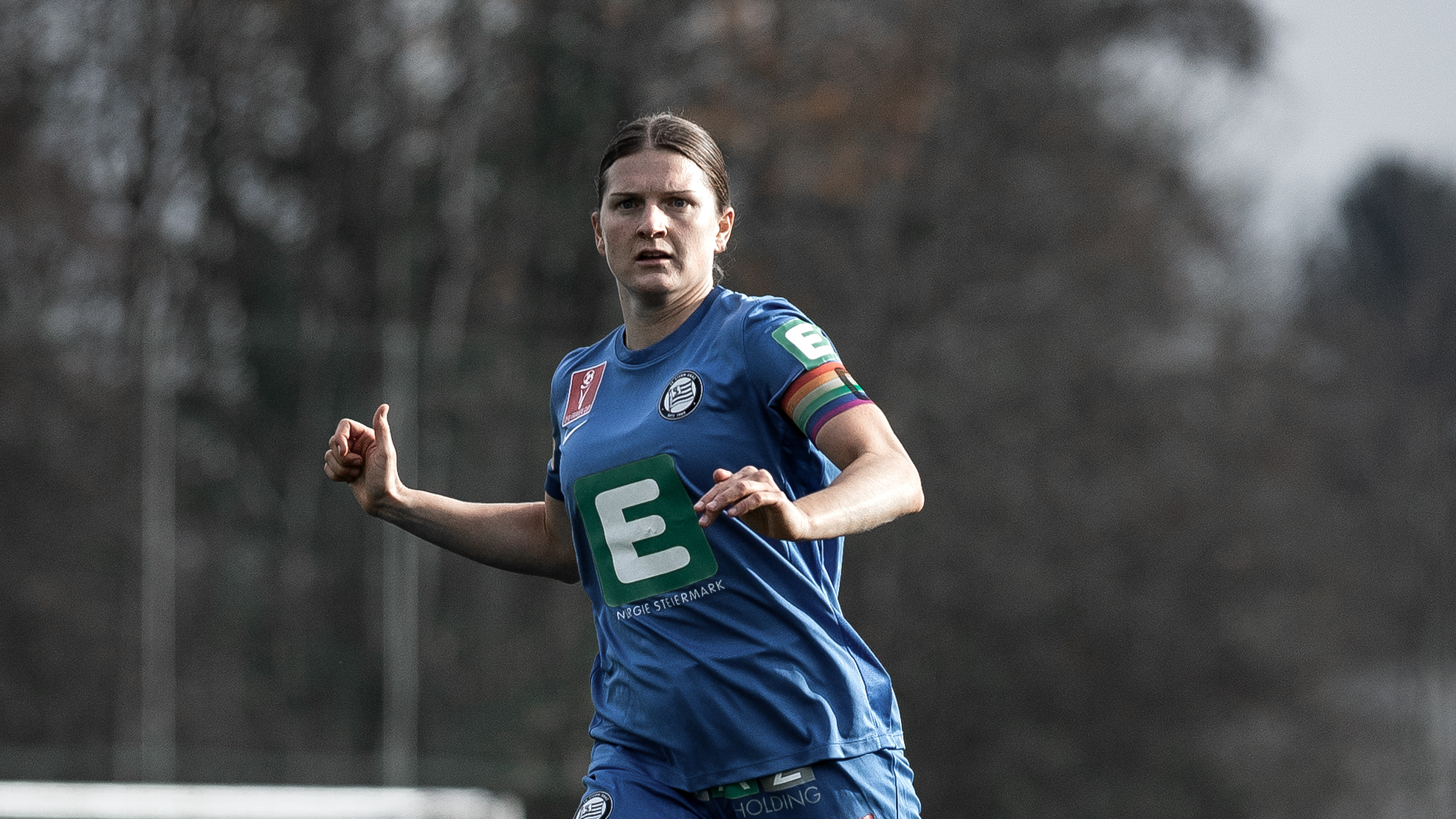 Eine Frau in einem blauen Trikots schaut konzentriert.