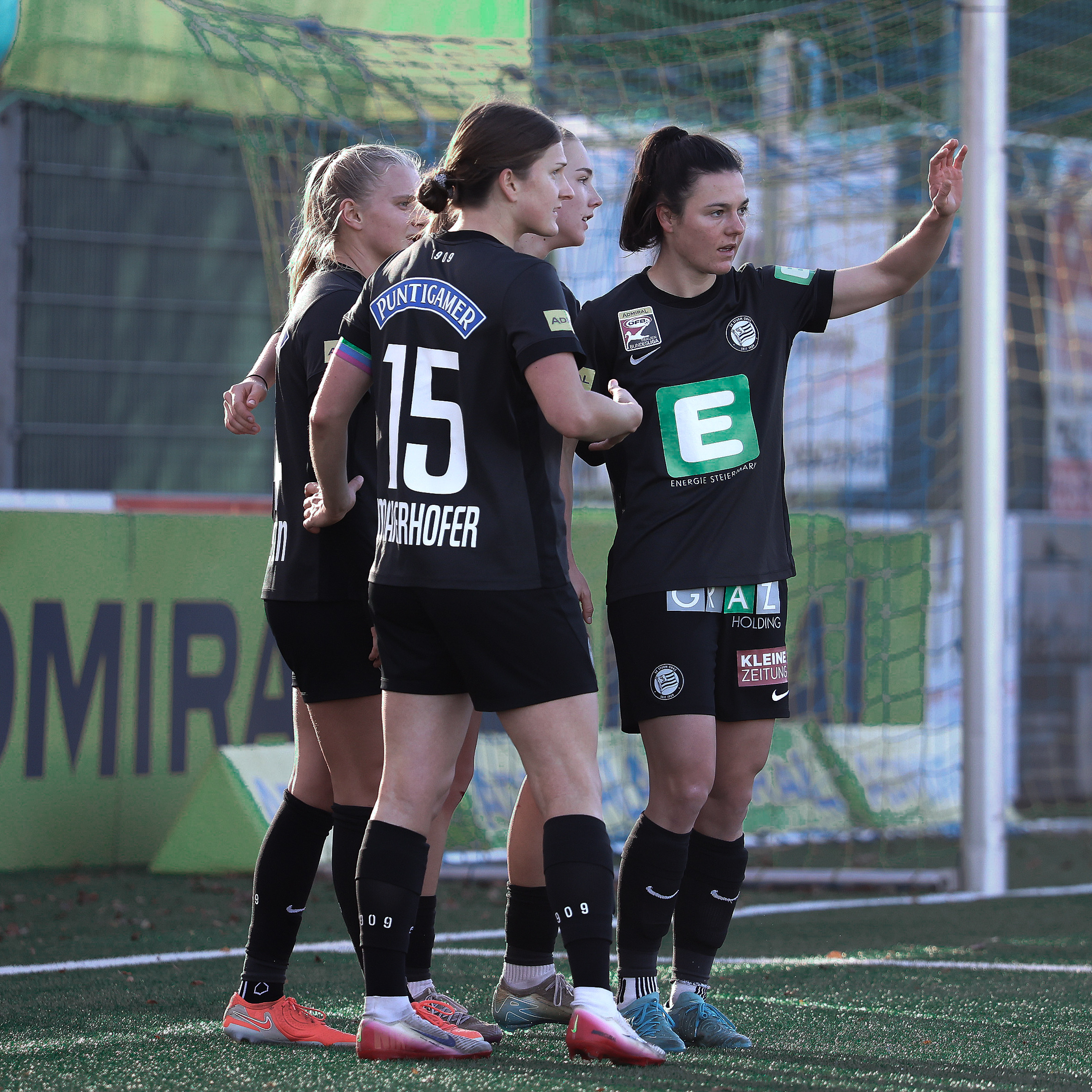 Vier Frauen in schwarzen Trikots jubeln gemeinsam.