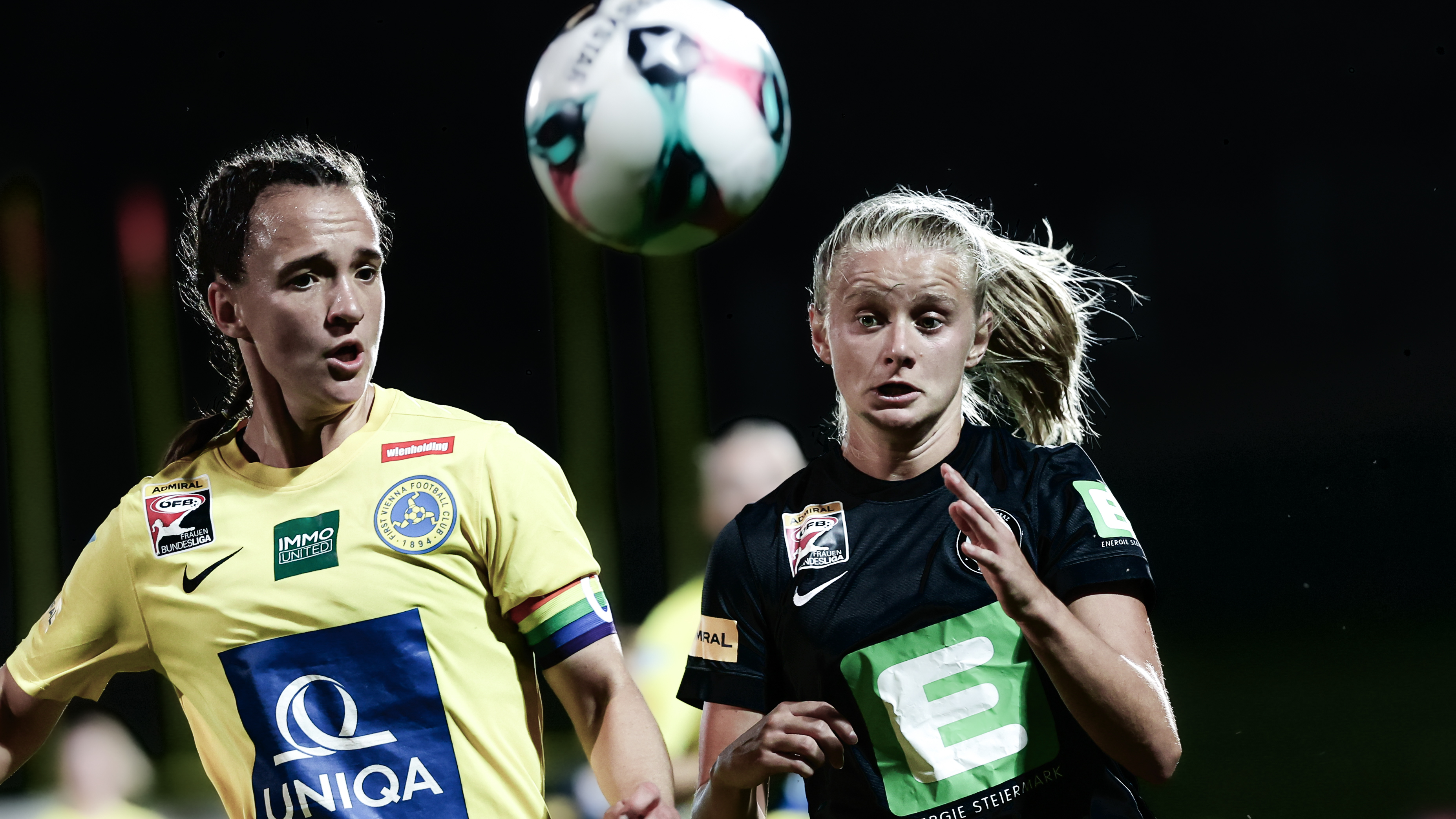 Eine Spielerin in gelb und eine in schwarz kämpfen um den Ball