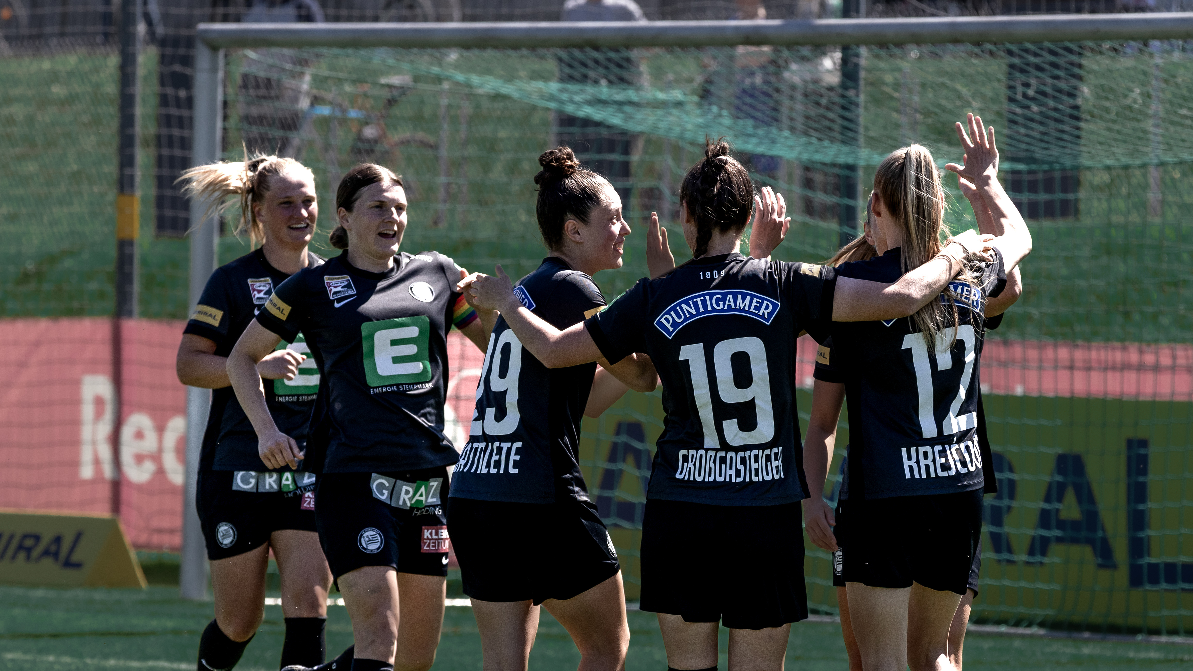 Fünf Frauen in schwarzen Trikots jubeln gemeinsam.