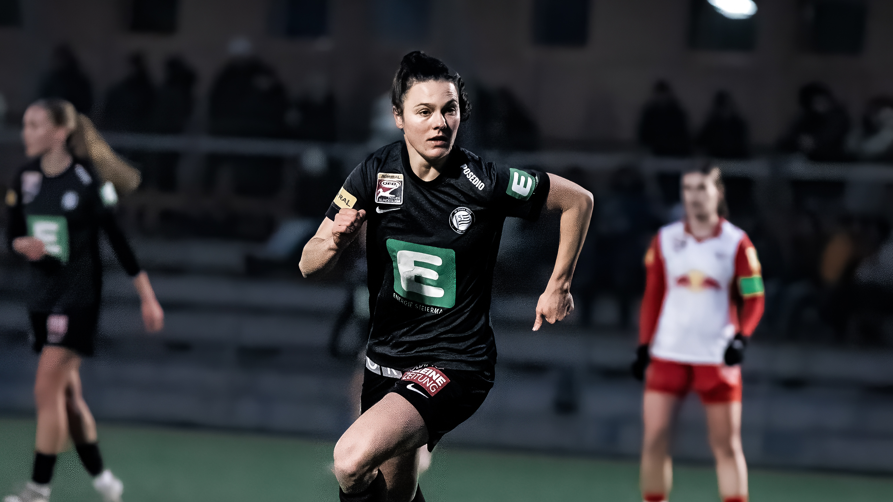 Eine Frau in schwarzen Trikots läuft einem weißen Ball hinterher.