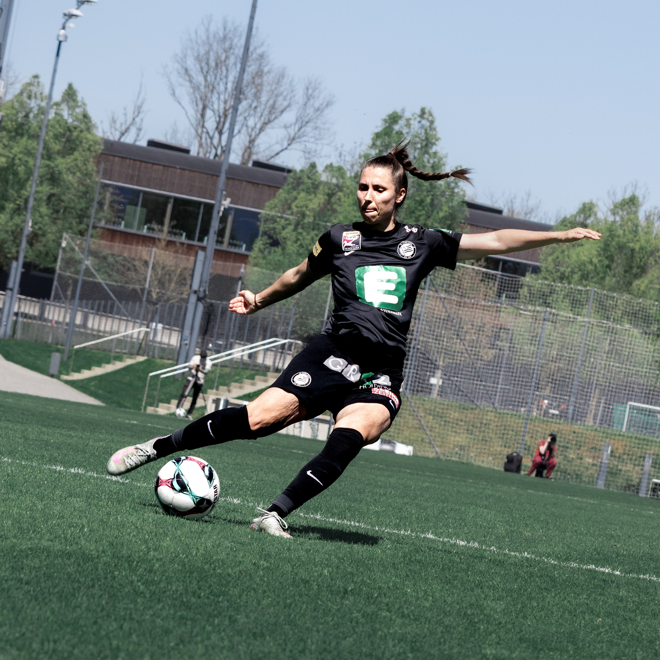 Eine Frau in schwarzem Trikot holt zum Schuss aus.