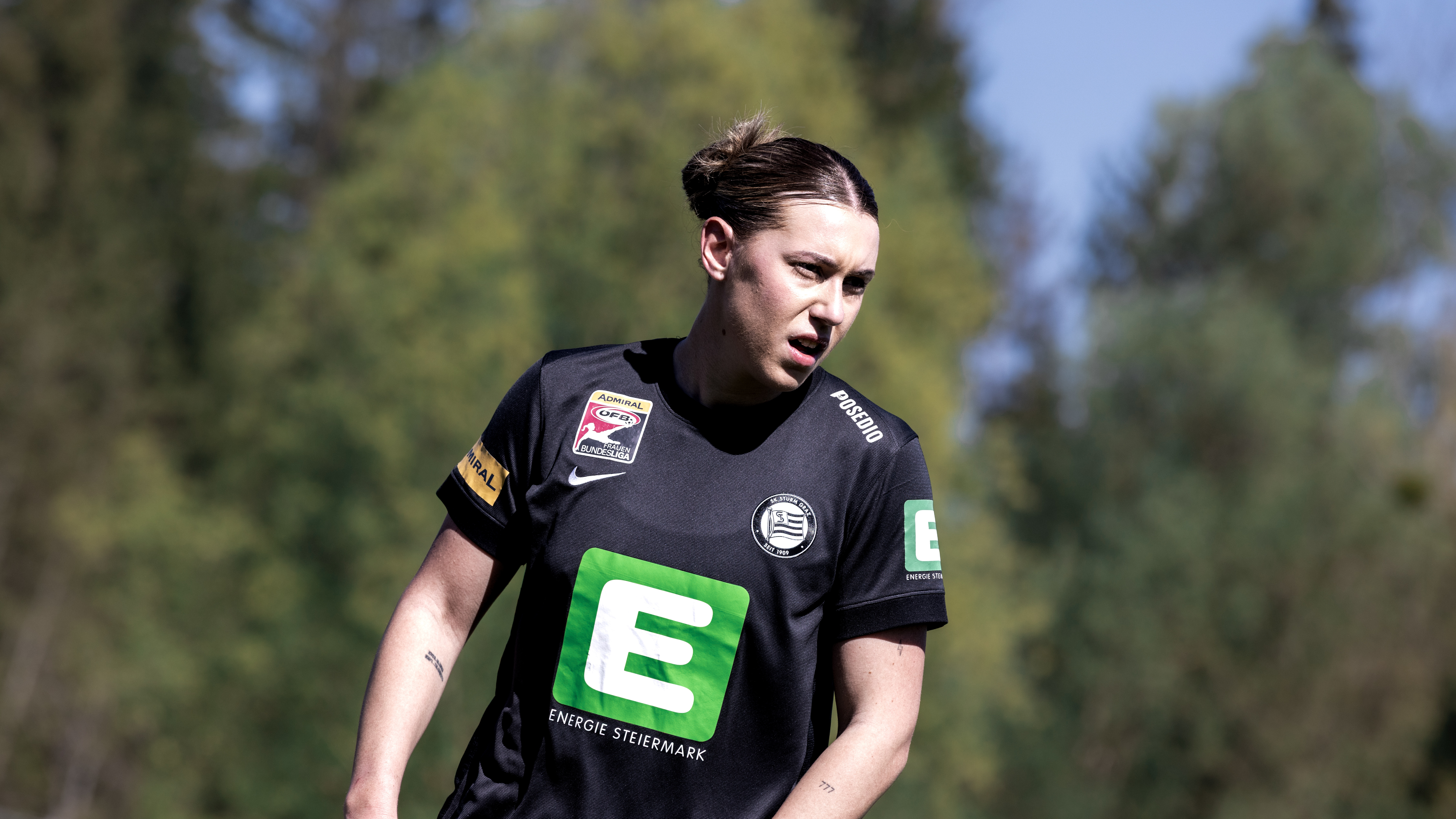 Eine Frau in schwarzem Trikot schaut in die Ferne.