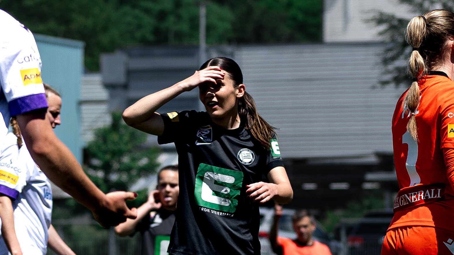 Eine Frau in schwarzem Trikot fasst sich an den Kopf.