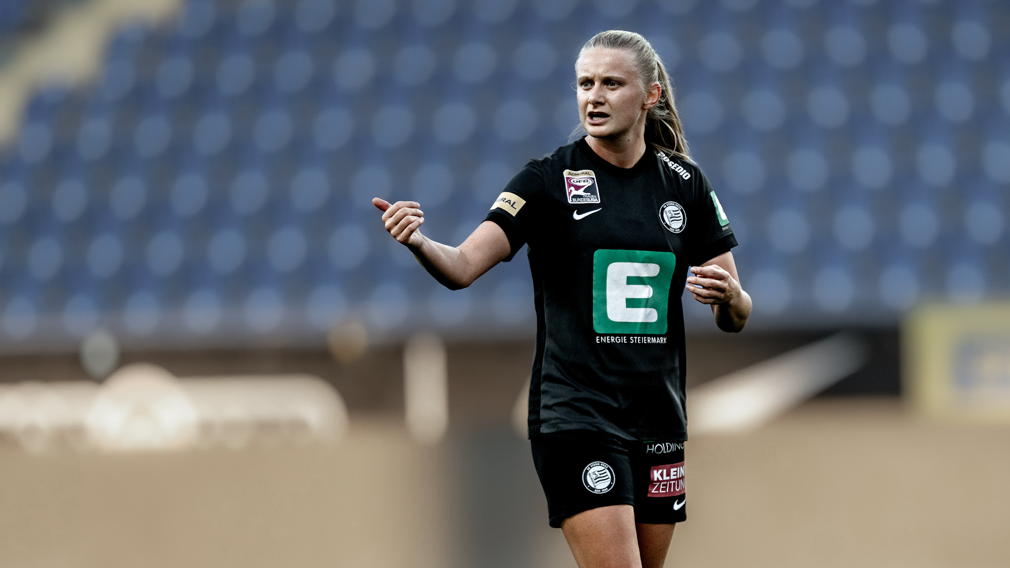 Eine Spielerin in schwarzem Trikot fordert mit ihren Händen einen Ball.