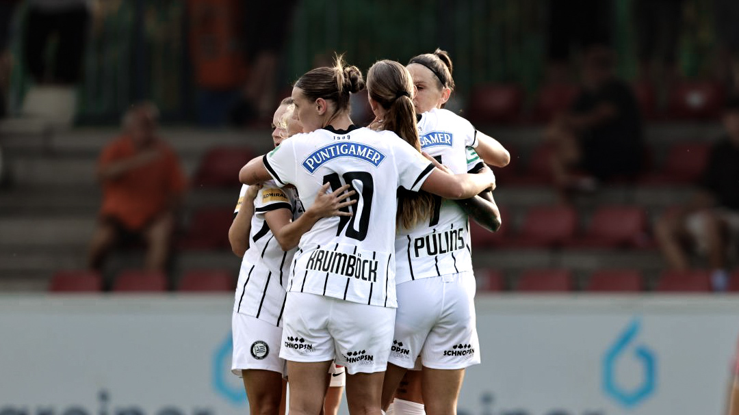Einige Frauen in weißem Shirts jubeln miteinander.