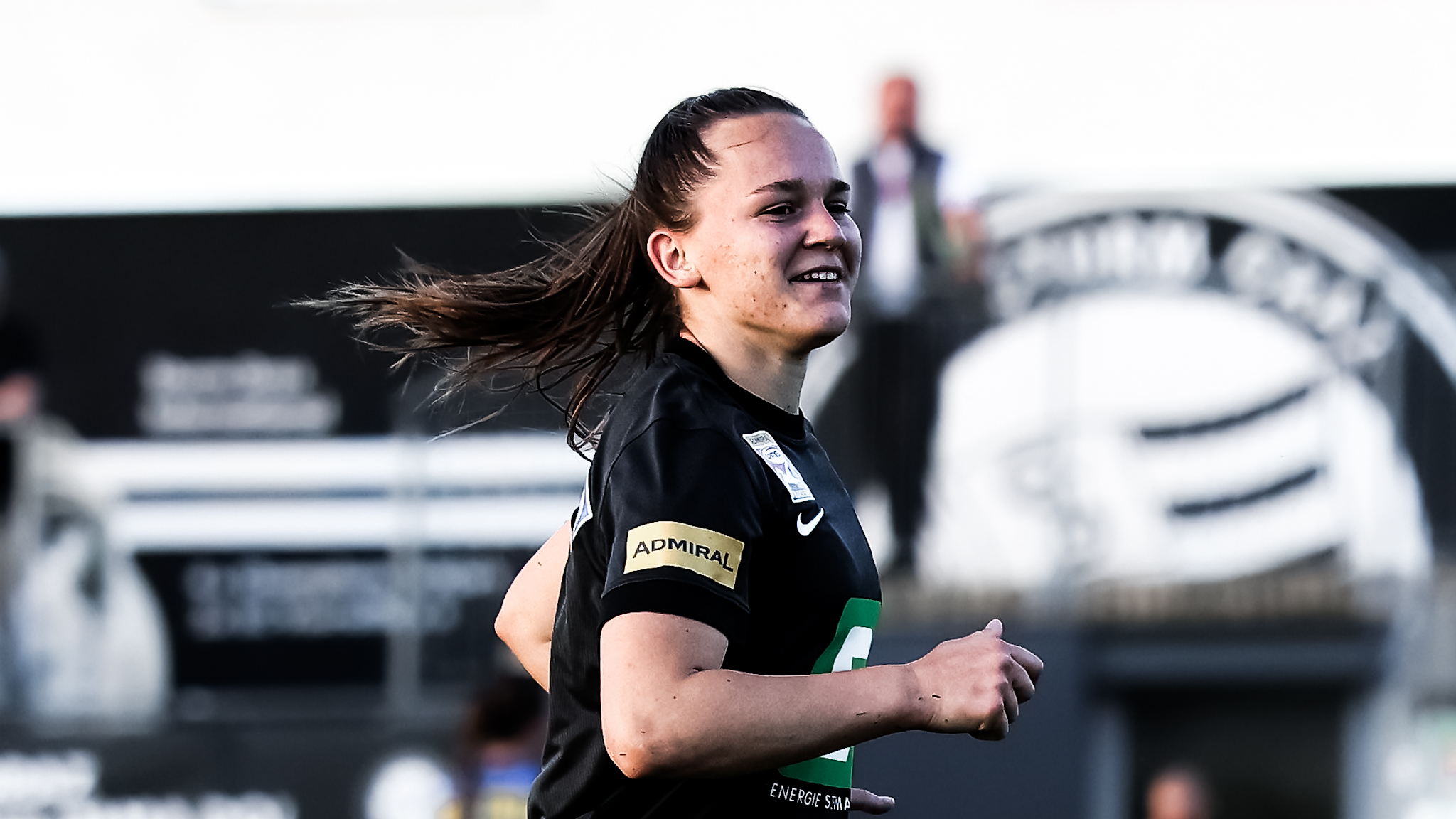 Eine Spielerin in einem schwarzen Trikot läuft und lacht