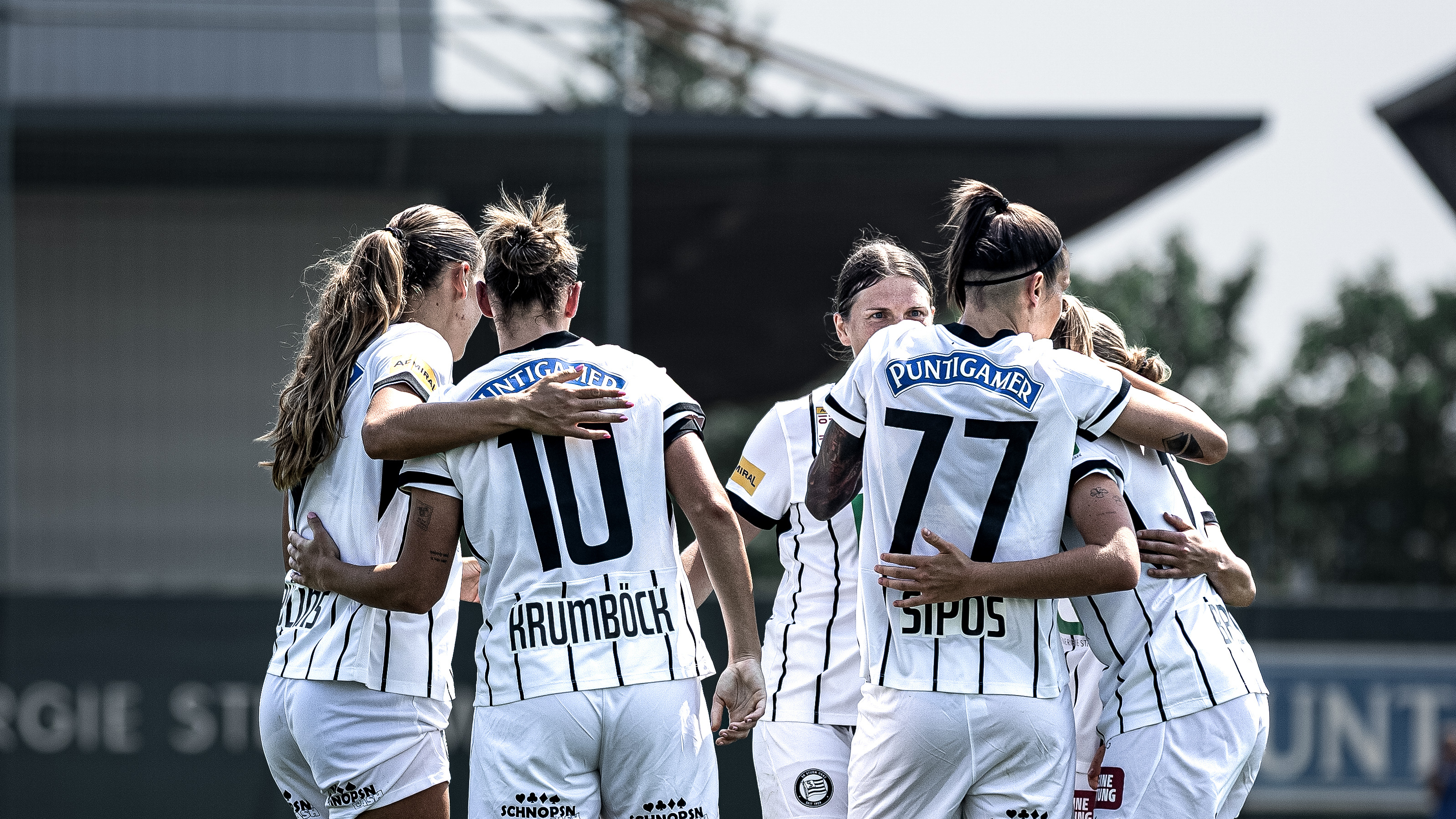 Einige Frauen in weißen Trikots jubeln gemeinsam.