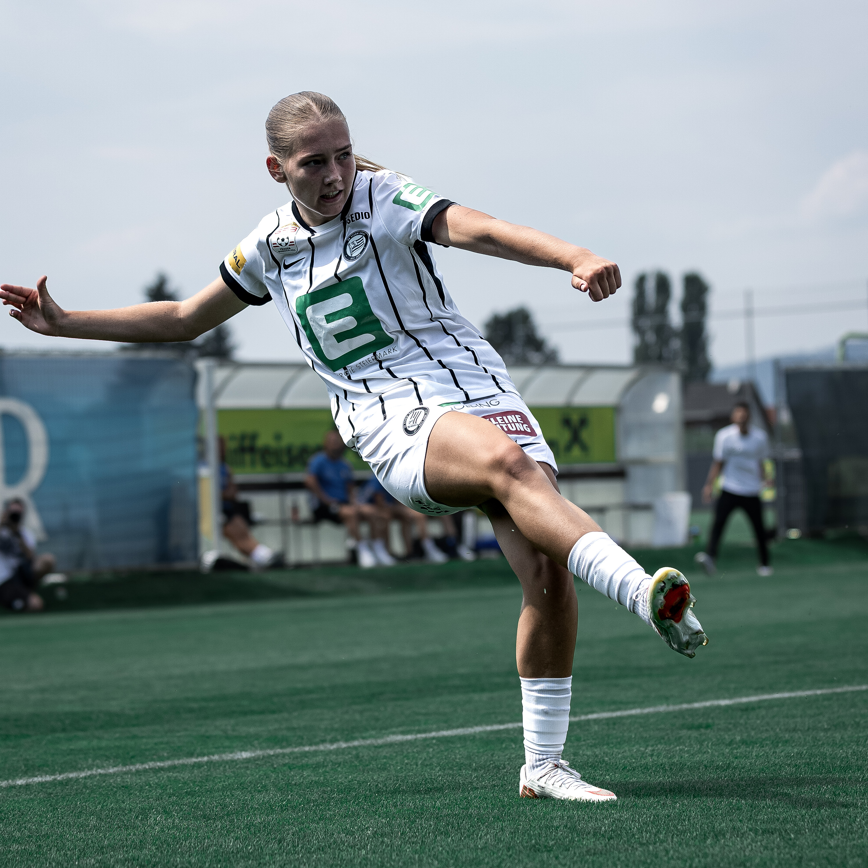 Eine Frau mit weißem Trikot macht einen Pass.