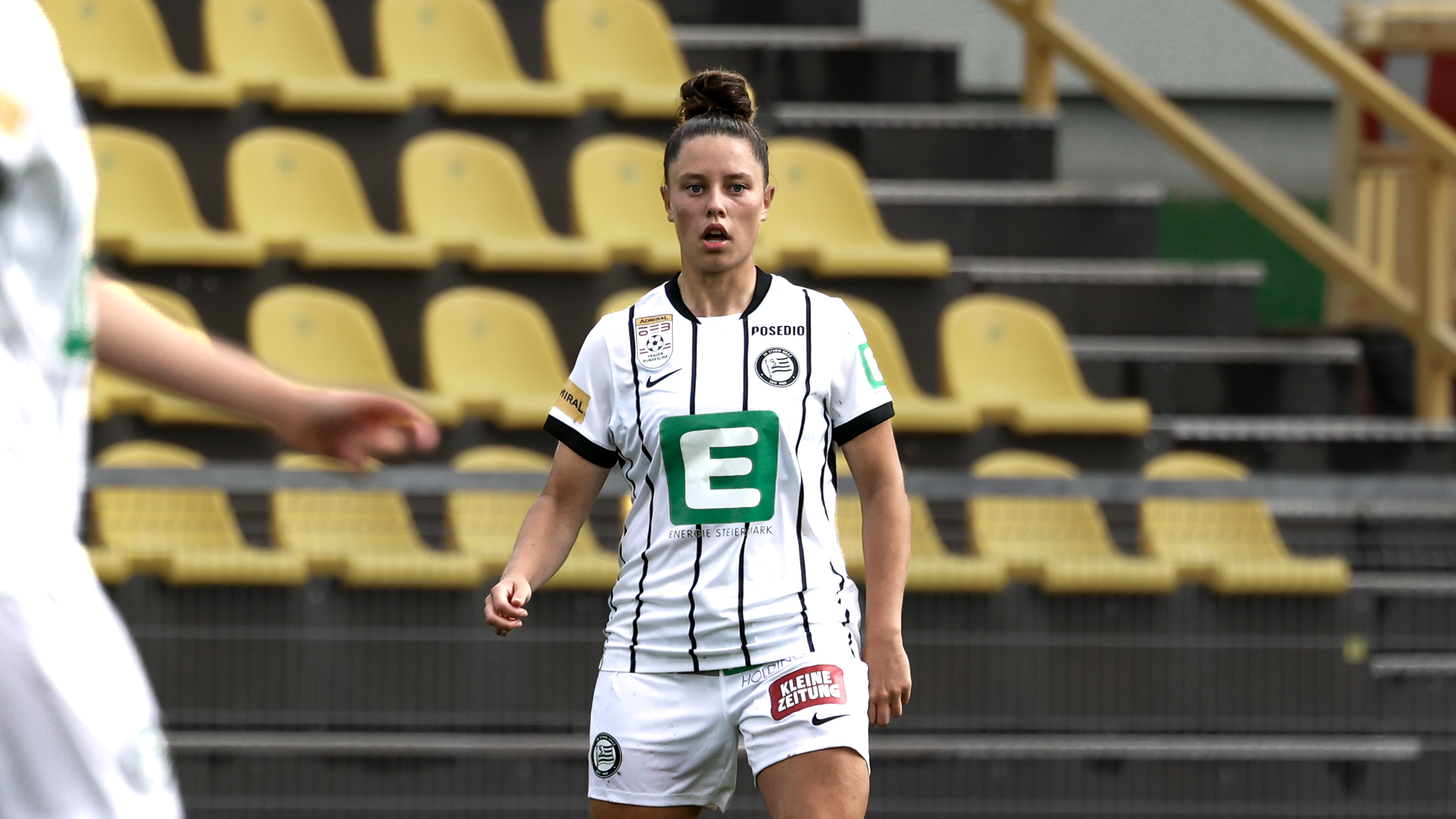 Eine Frau in weißem Trikot schaut konzentriert.