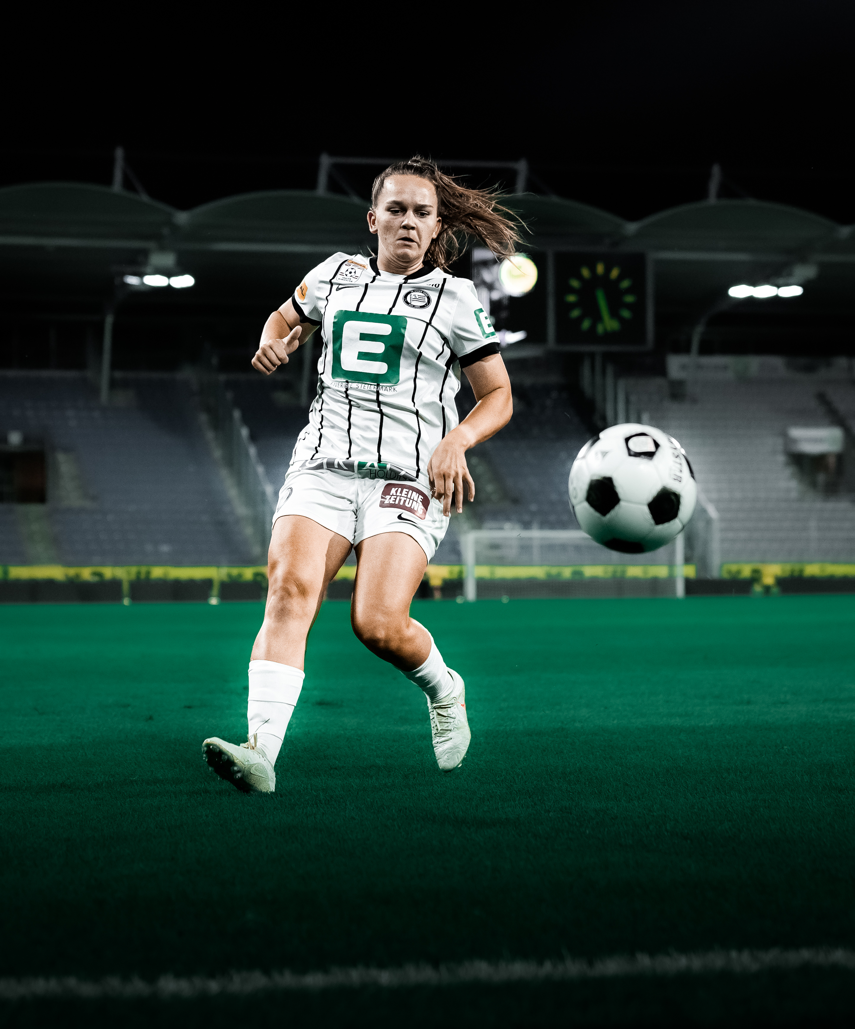 Eine Spielerin in einem weißen Trikot läuft einem weißen Ball nach