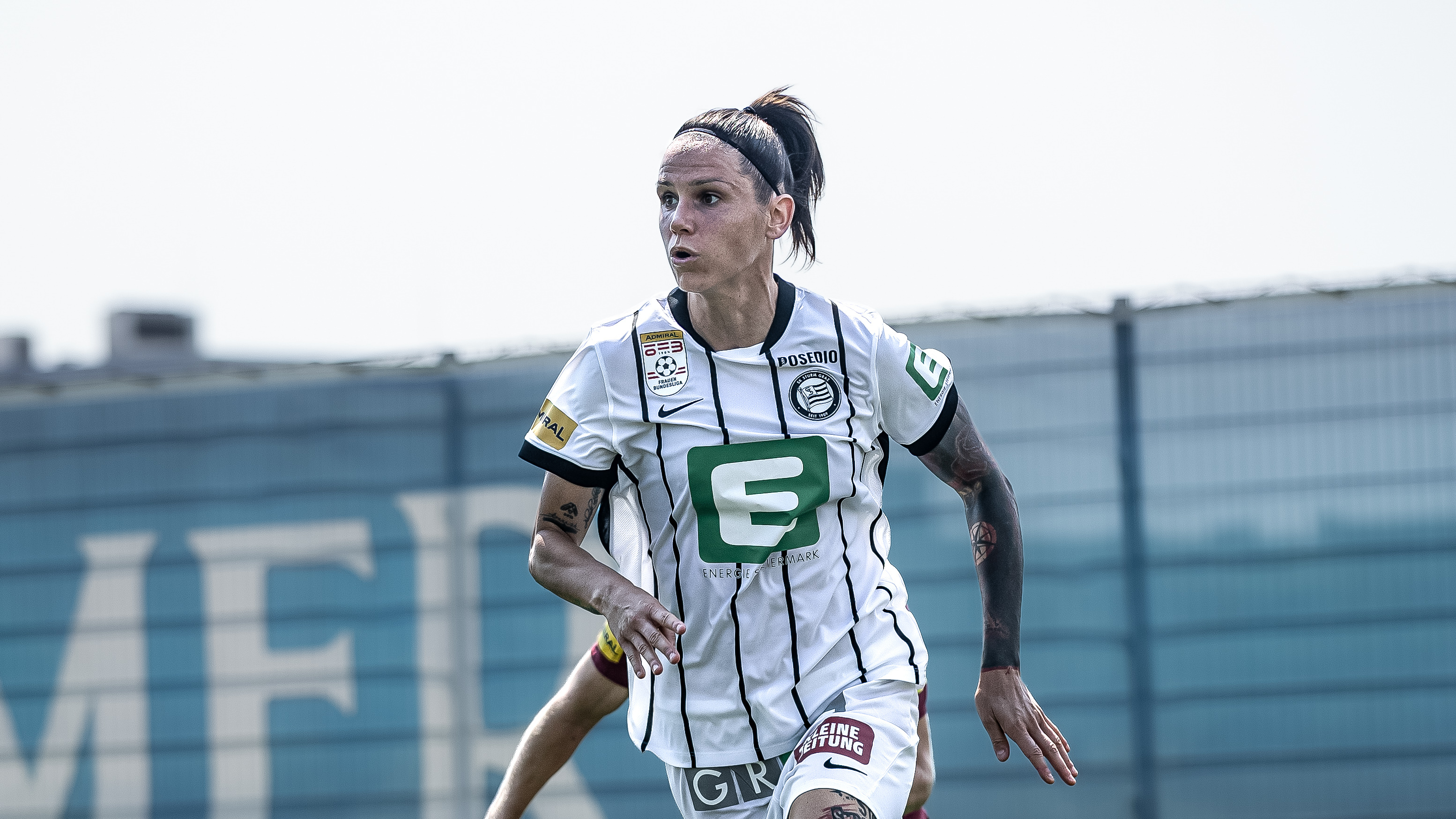 Eine Frau in weißem Trikot schaut konzentriert.