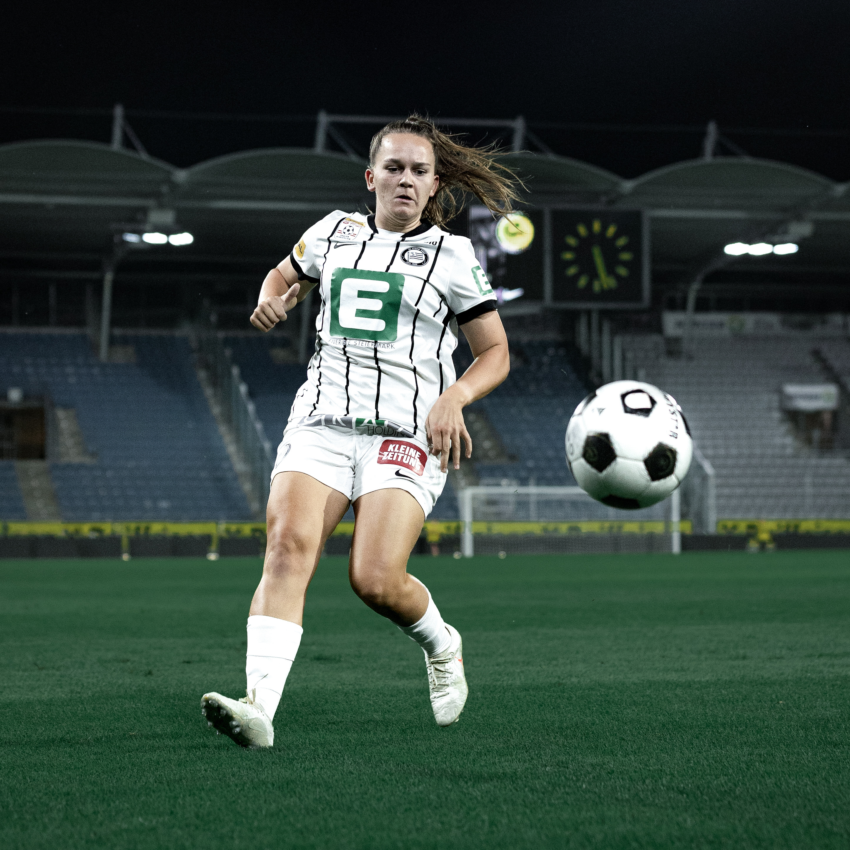 Eine Frau in weißem Trikot läuft zum Ball.