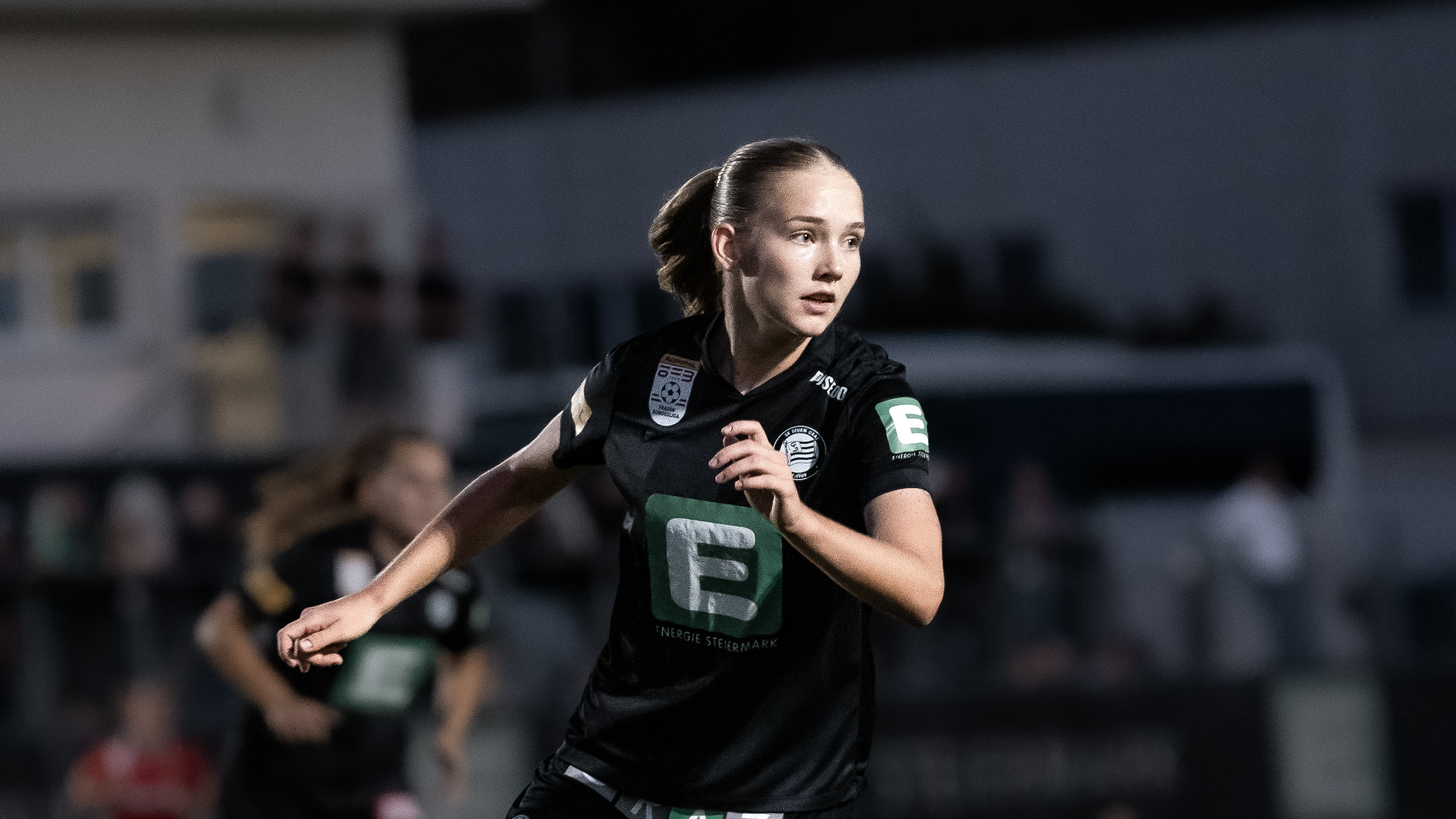 Eine Frau in schwarzem Trikot schaut konzentriert.