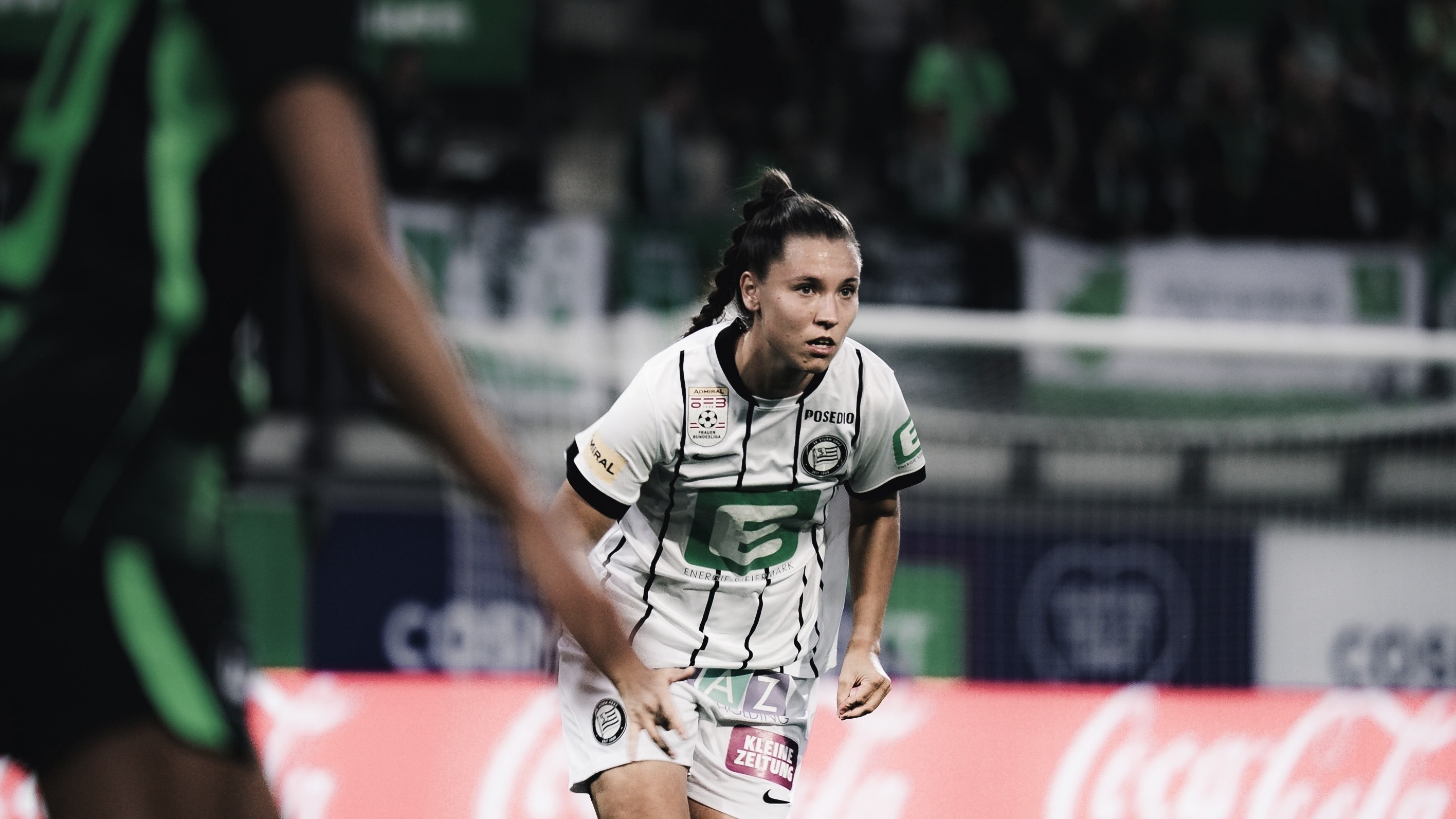 Eine Frau in weißem Trikot schaut konzentriert.
