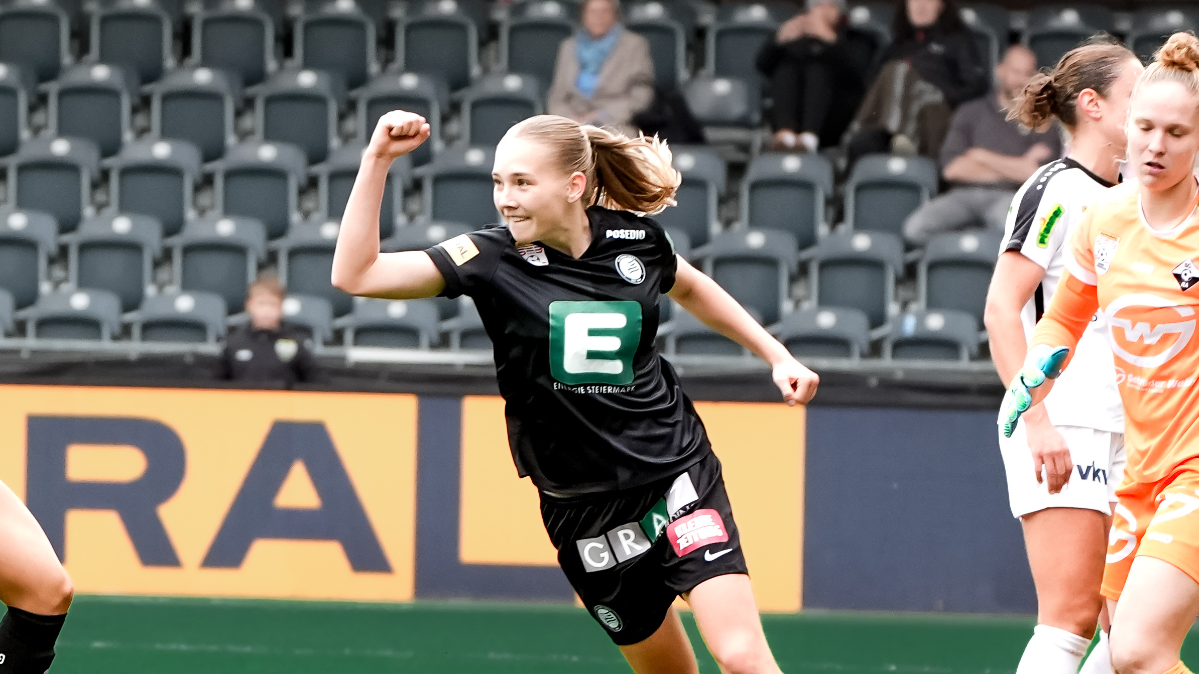 Eine Frau in schwarzem Trikot jubelt.