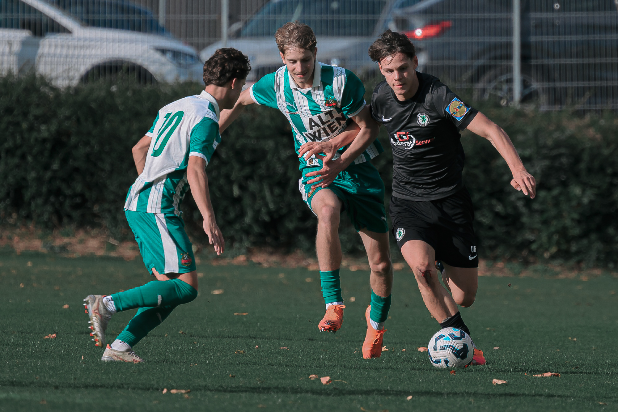 Drei Burschen beim Fußballspielen.