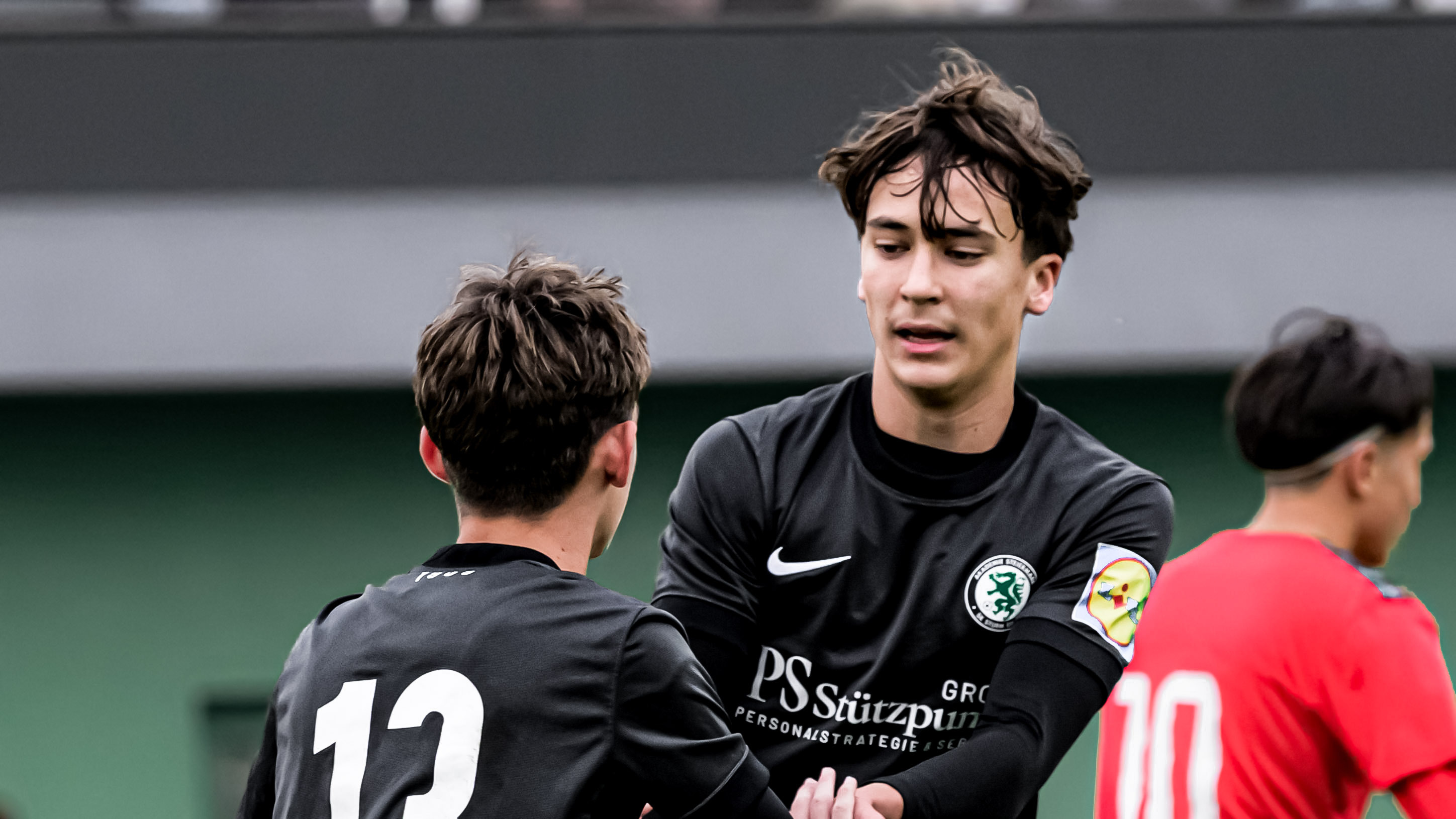 Zwei junge Spieler in einem schwarzen Trikot die jubeln