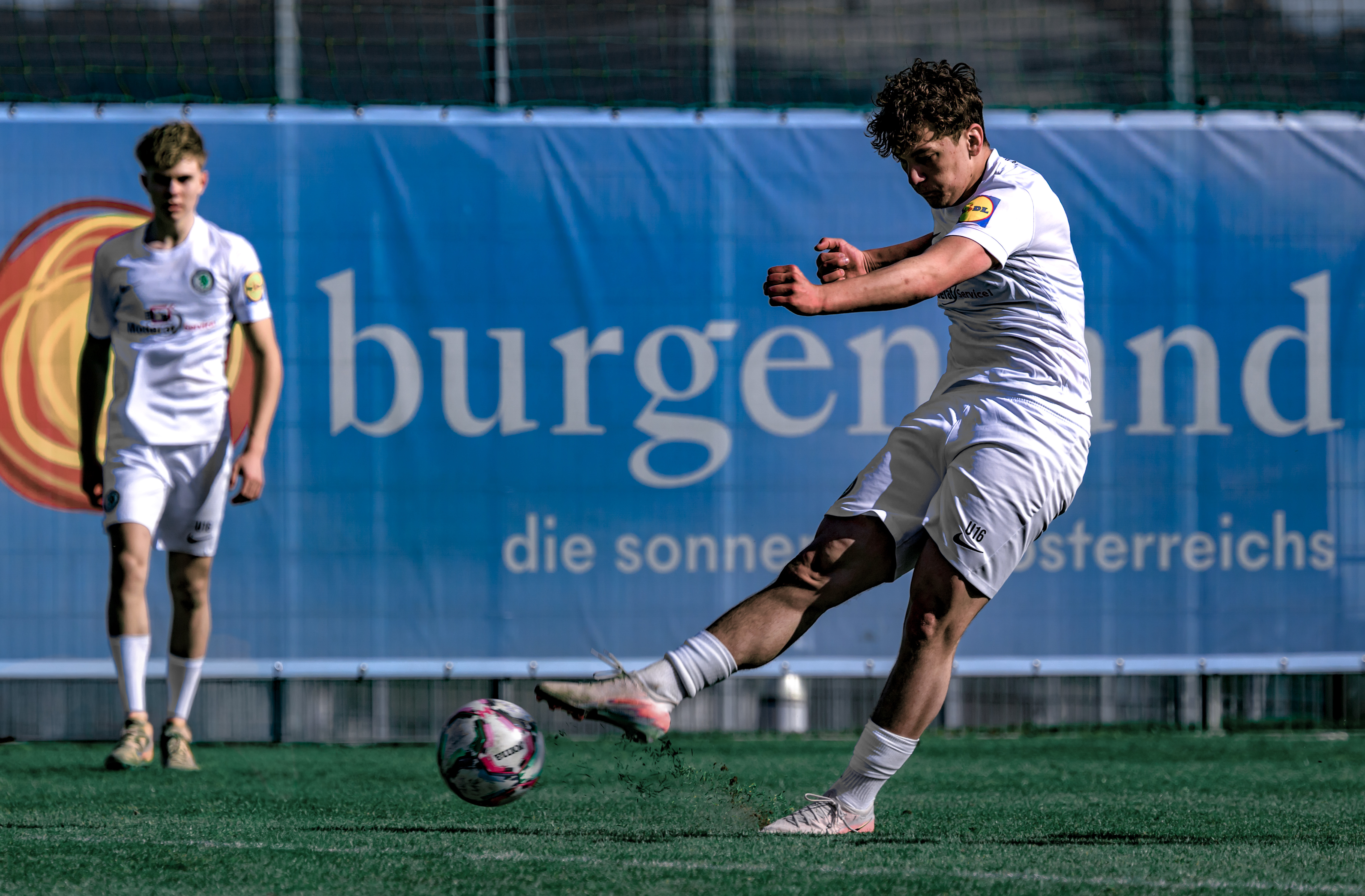Zwei junge Männer spielen Fußball.