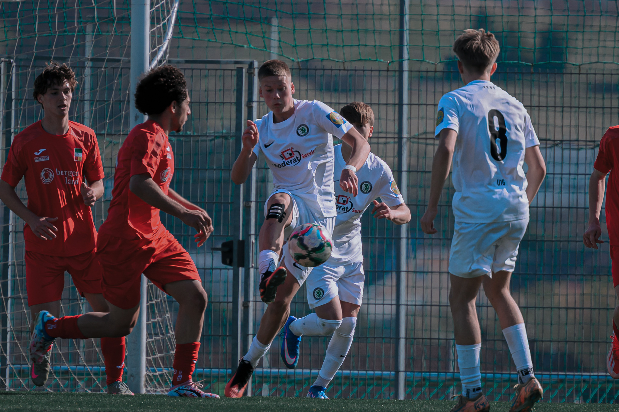 Fünf junge Männer spielen Fußball.