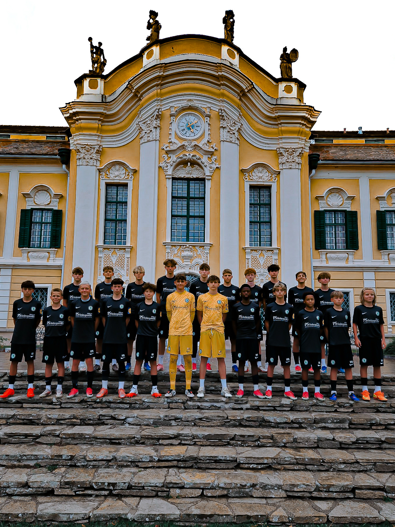 Eine Fußballmannschaft posiert vor einem Schloss.