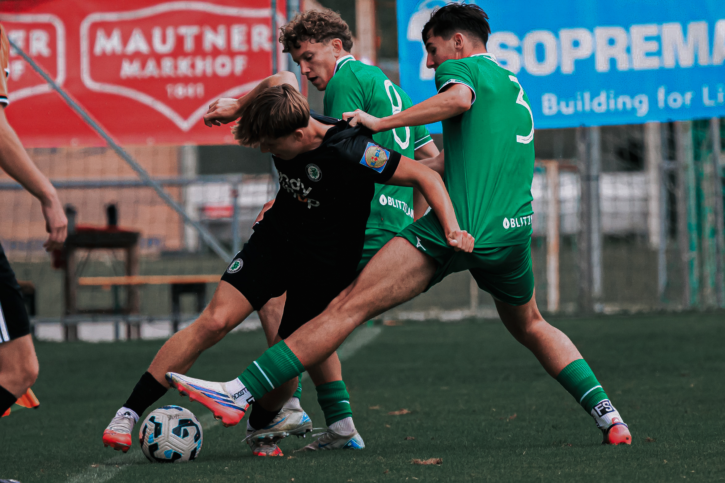 Drei Fußball im Kampf um den Ball.
