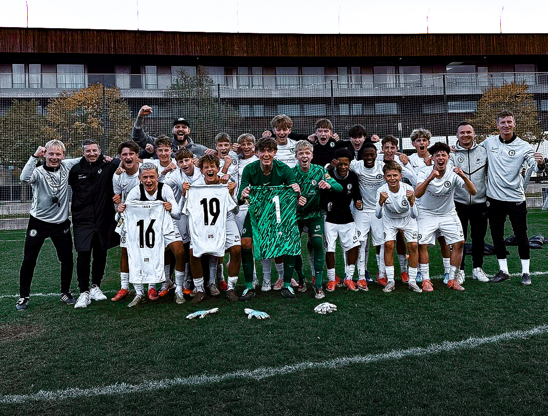 Eine Fußballmannschaft und die Betreuer jubeln