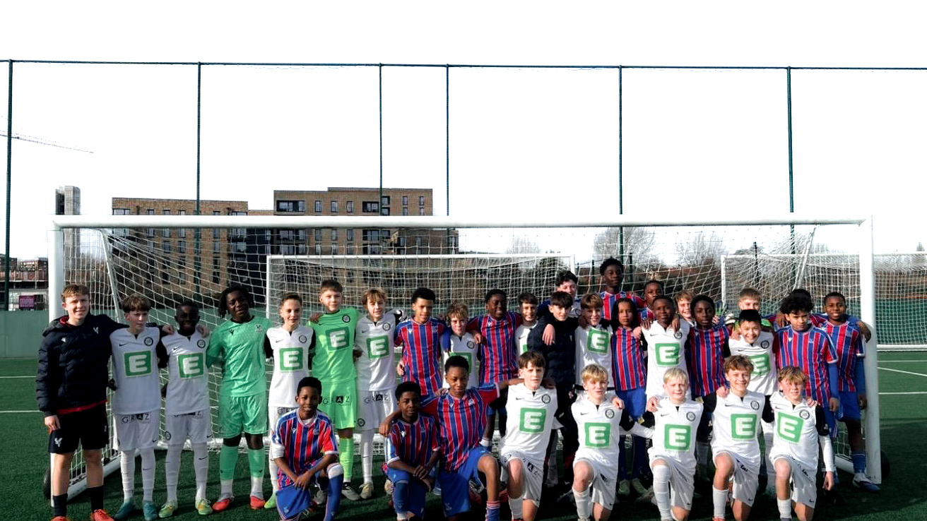 Zwei Fußballteams stehen zusammen für ein Gruppenfoto.