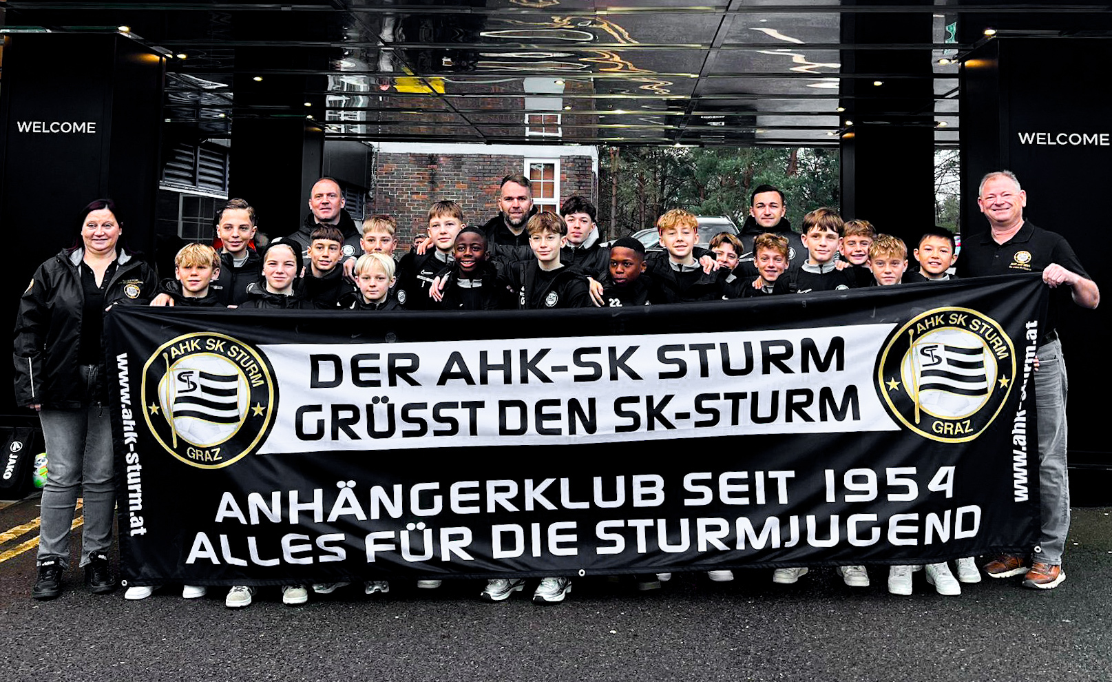 Eine Fußballmannschaft posiert vor einem Hotel.