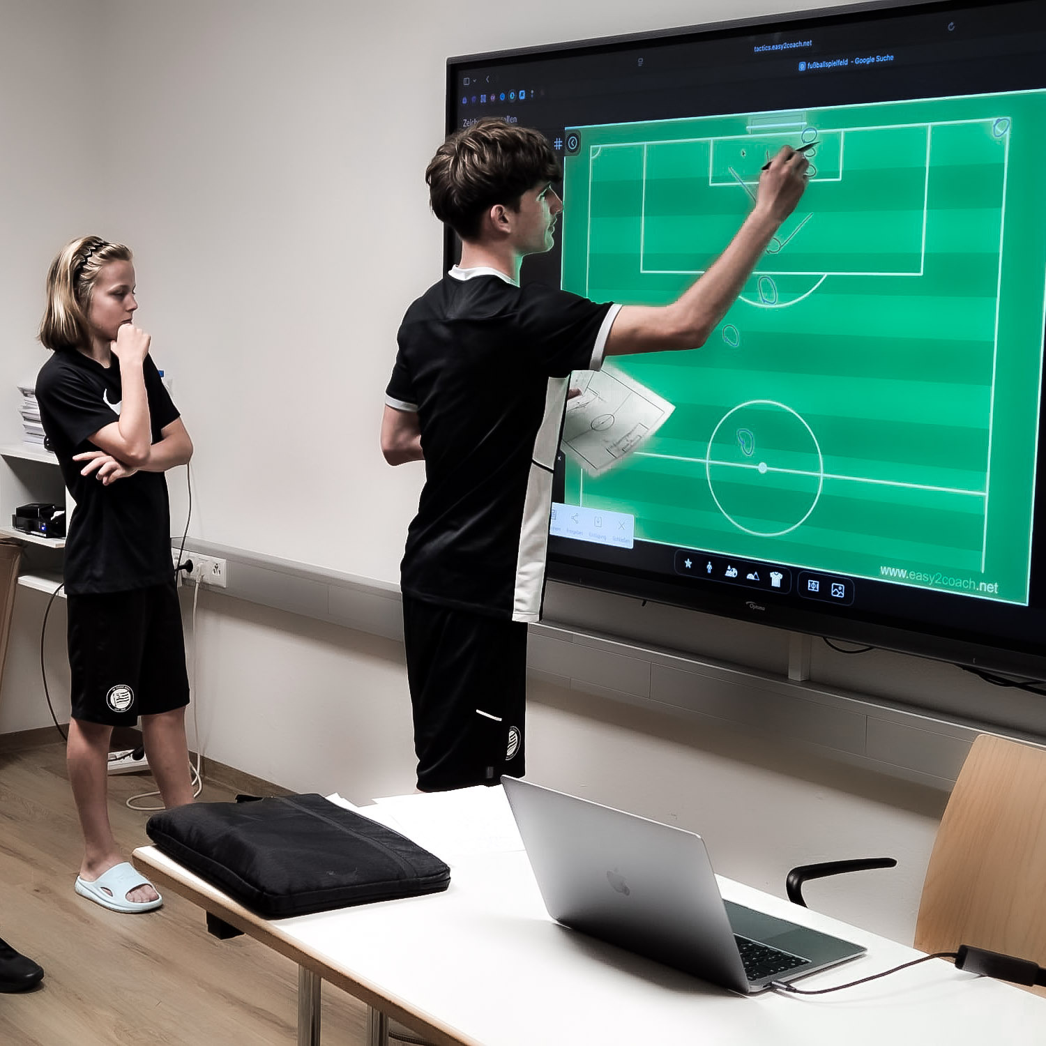 Zwei Nachwuchsspieler arbeiten an einer virtuellen Tafel