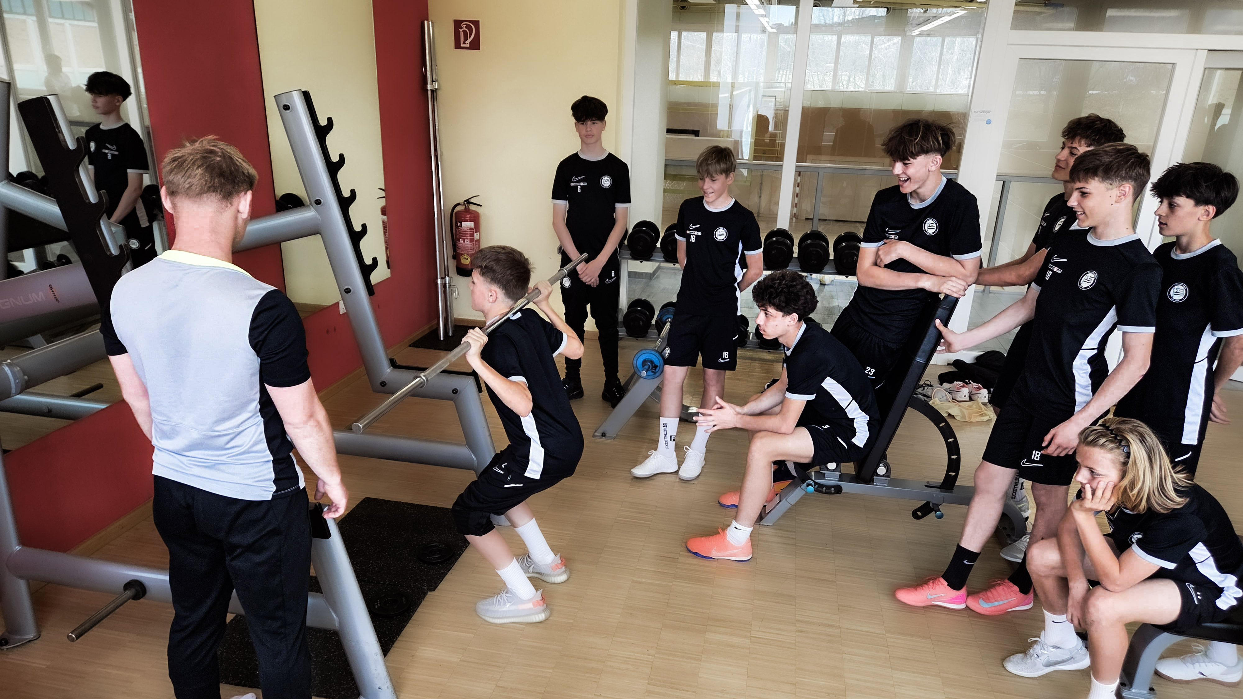 Viele junge Spieler trainieren im Gym und ein Trainer steht ihnen mit Rat und Tat zur Seite.