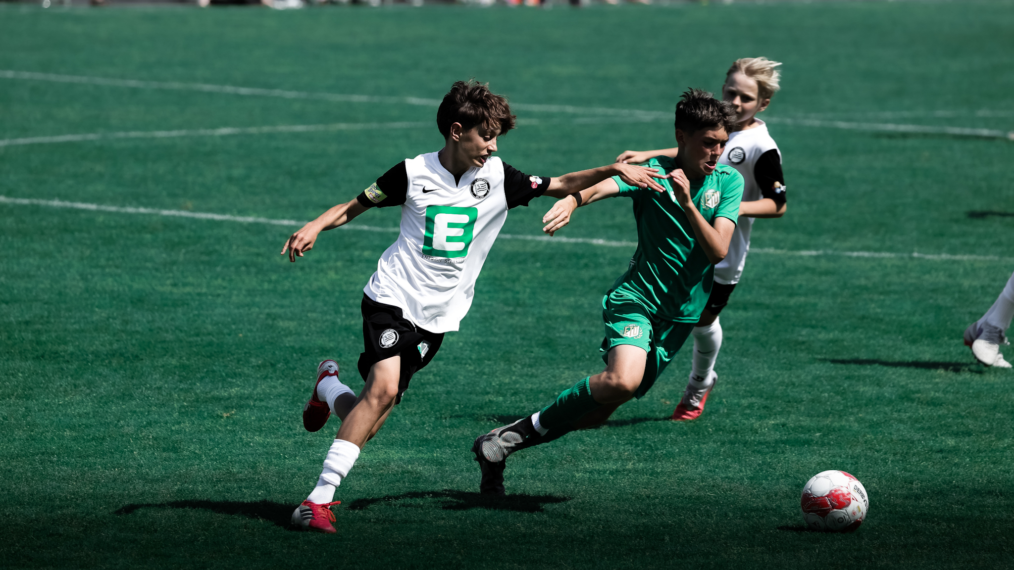 Zwei junge Spieler kämpfen um einen weißen Ball