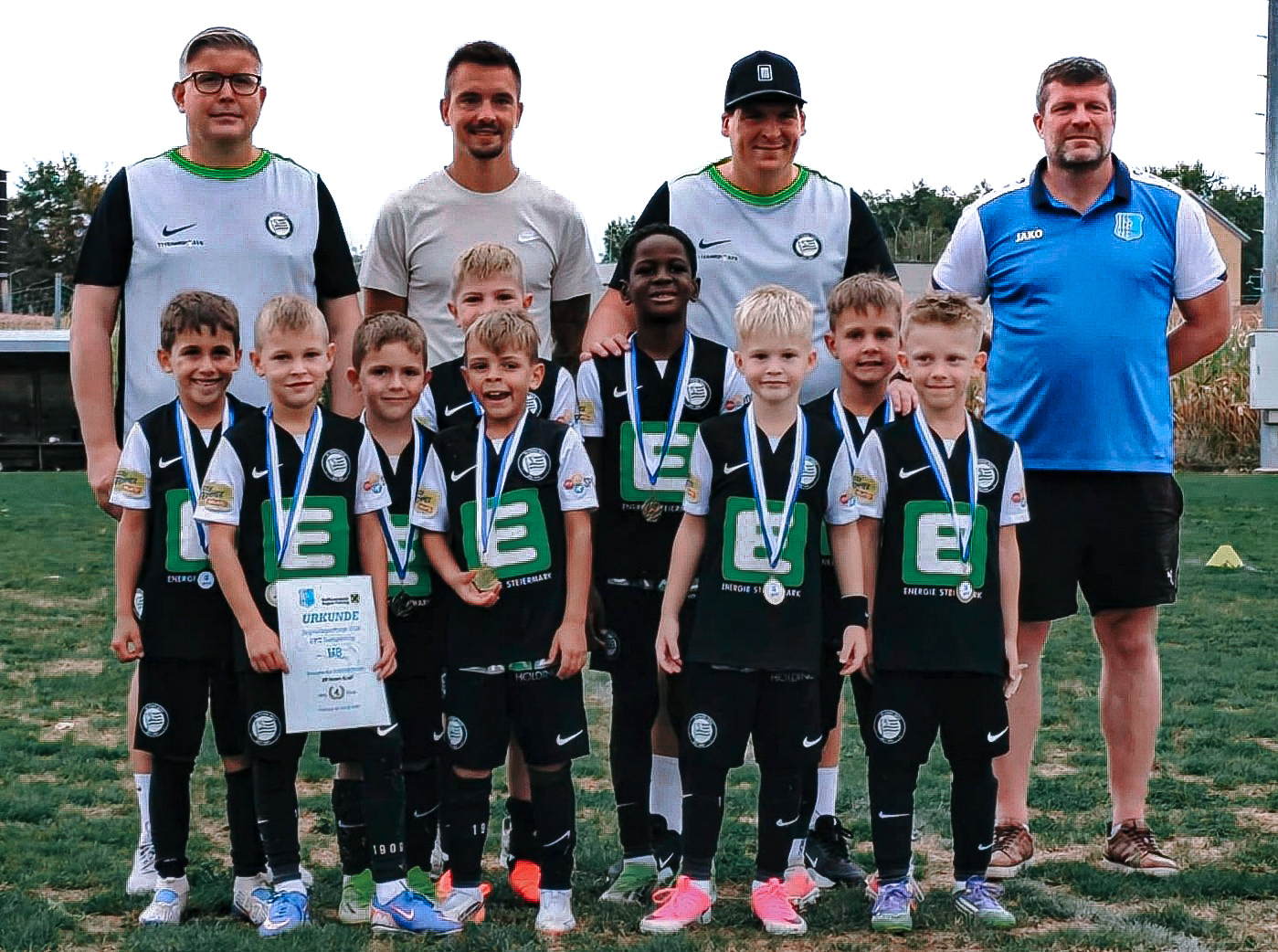 Eine junge Fußballmannschaft mit vier Betreuern.