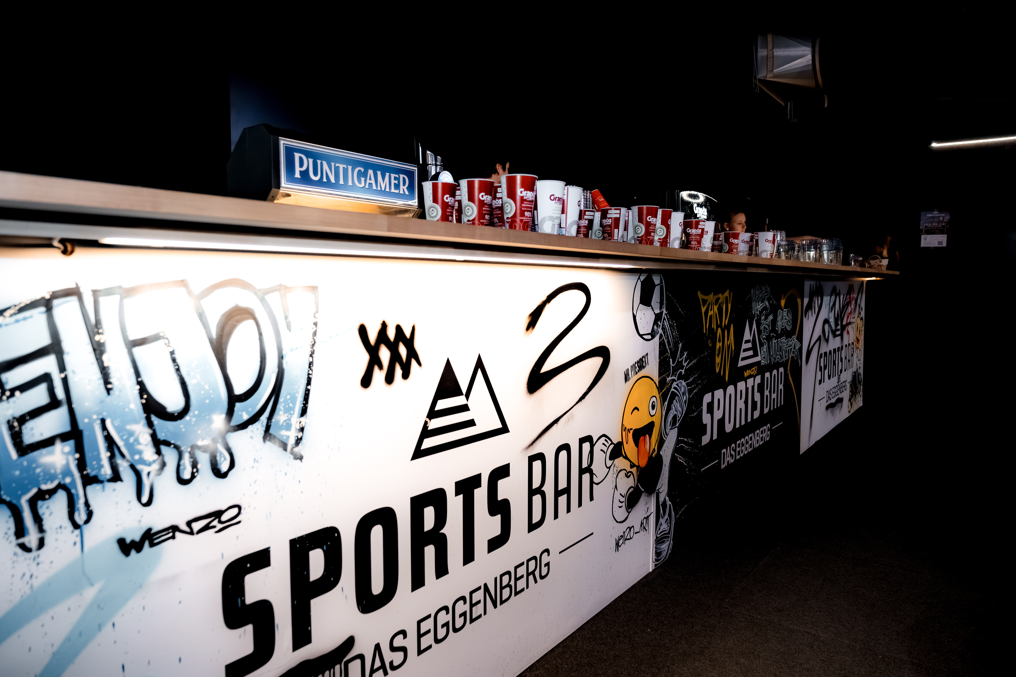 Eine Theke mit Grafiti in einer Sportsbar